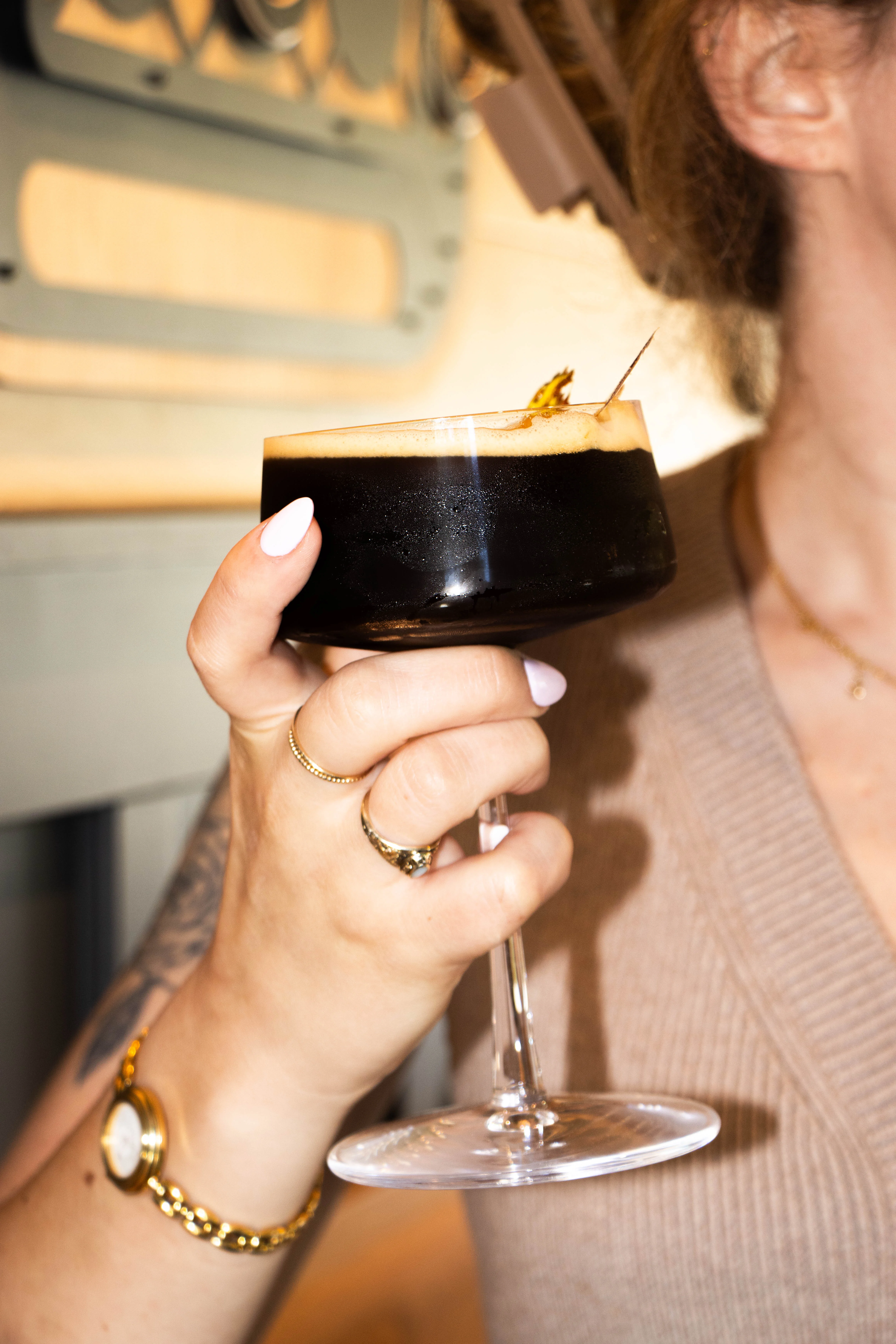 A Hand Holding an Espresso Martini in a coup glass