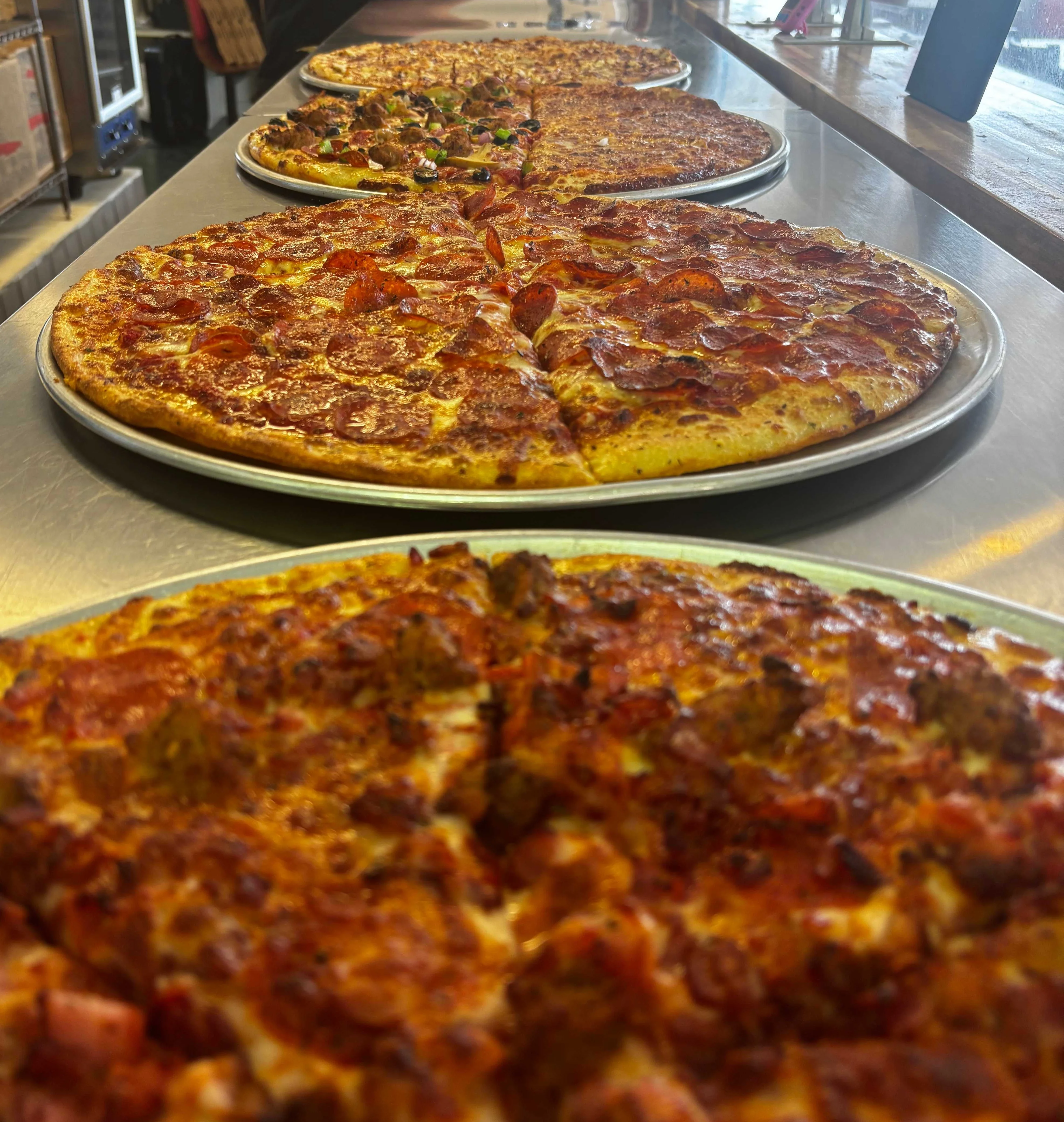 Variety of delicious pizzas on display at a pizzeria