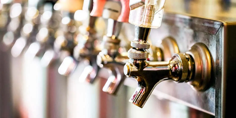 Close-up of beer taps at a modern bar