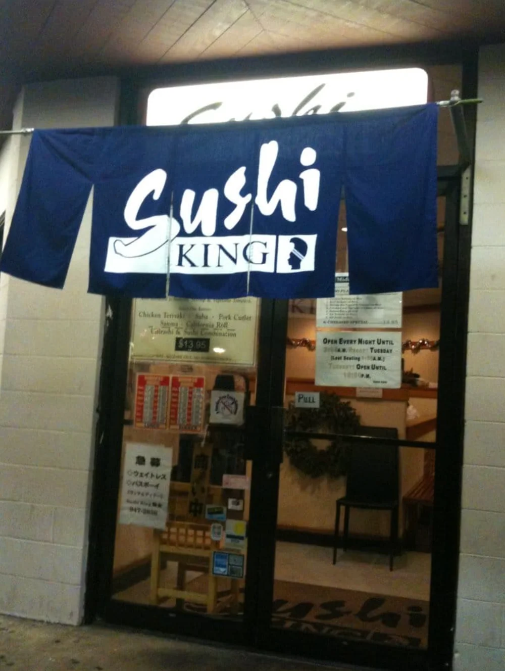 Entrance of Sushi King restaurant with a blue banner