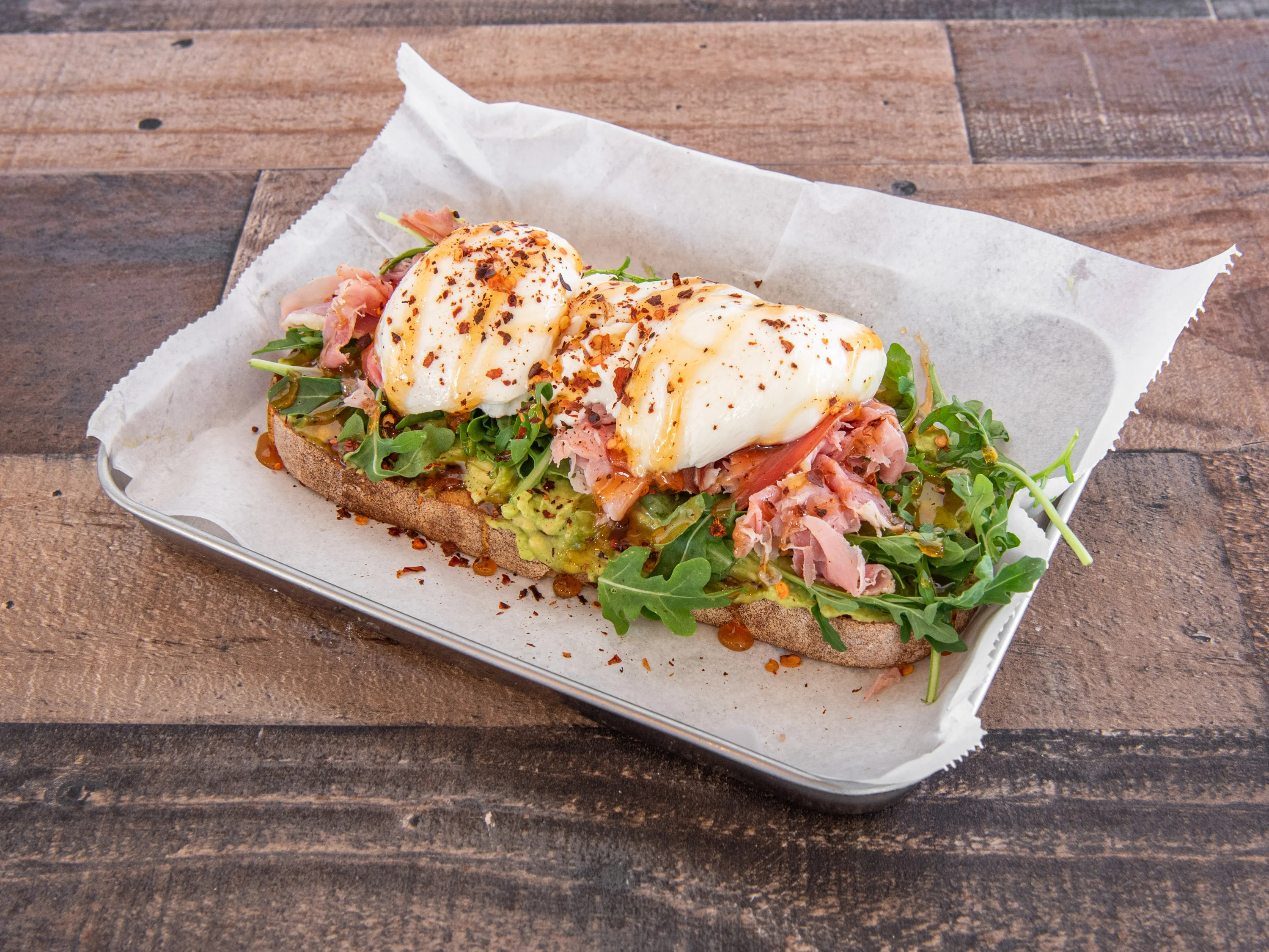 Avocado toast with poached eggs and prosciutto, a popular brunch dish