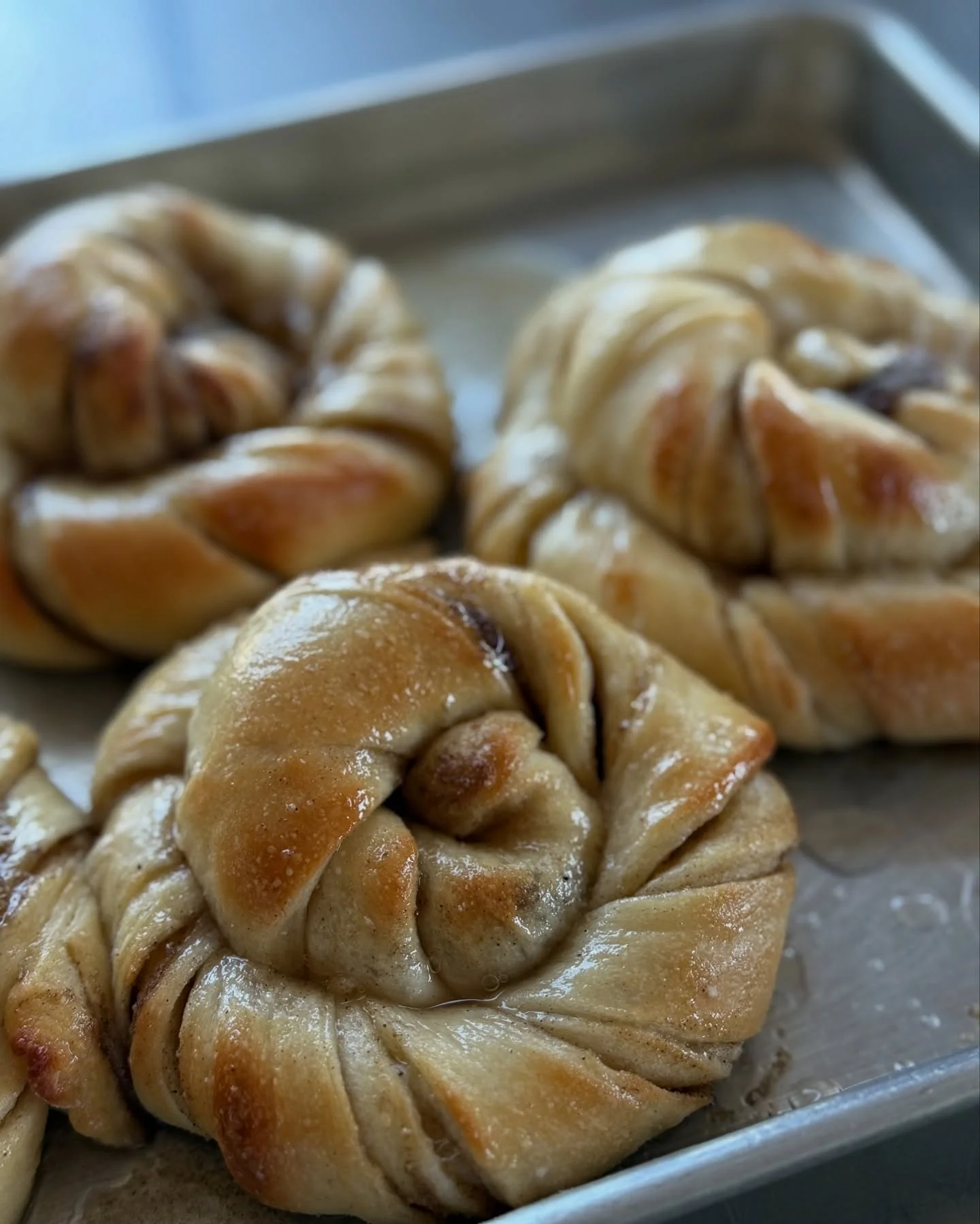 Freshly baked cinnamon rolls on a baking tray