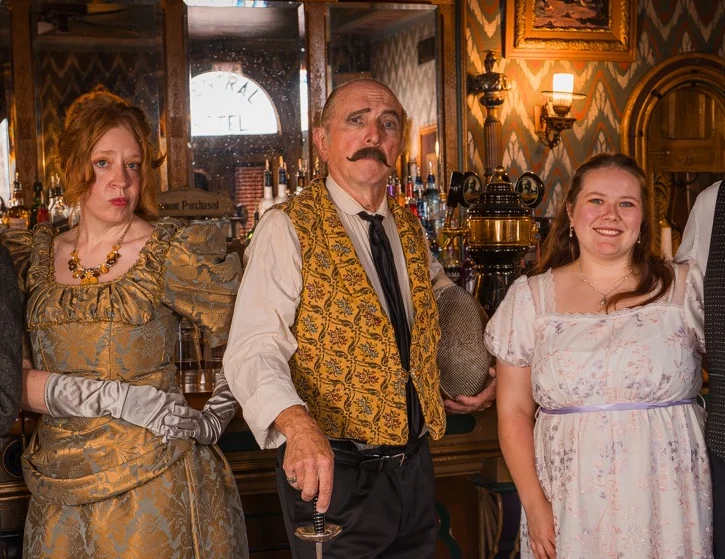 Group of people in vintage attire at a bar