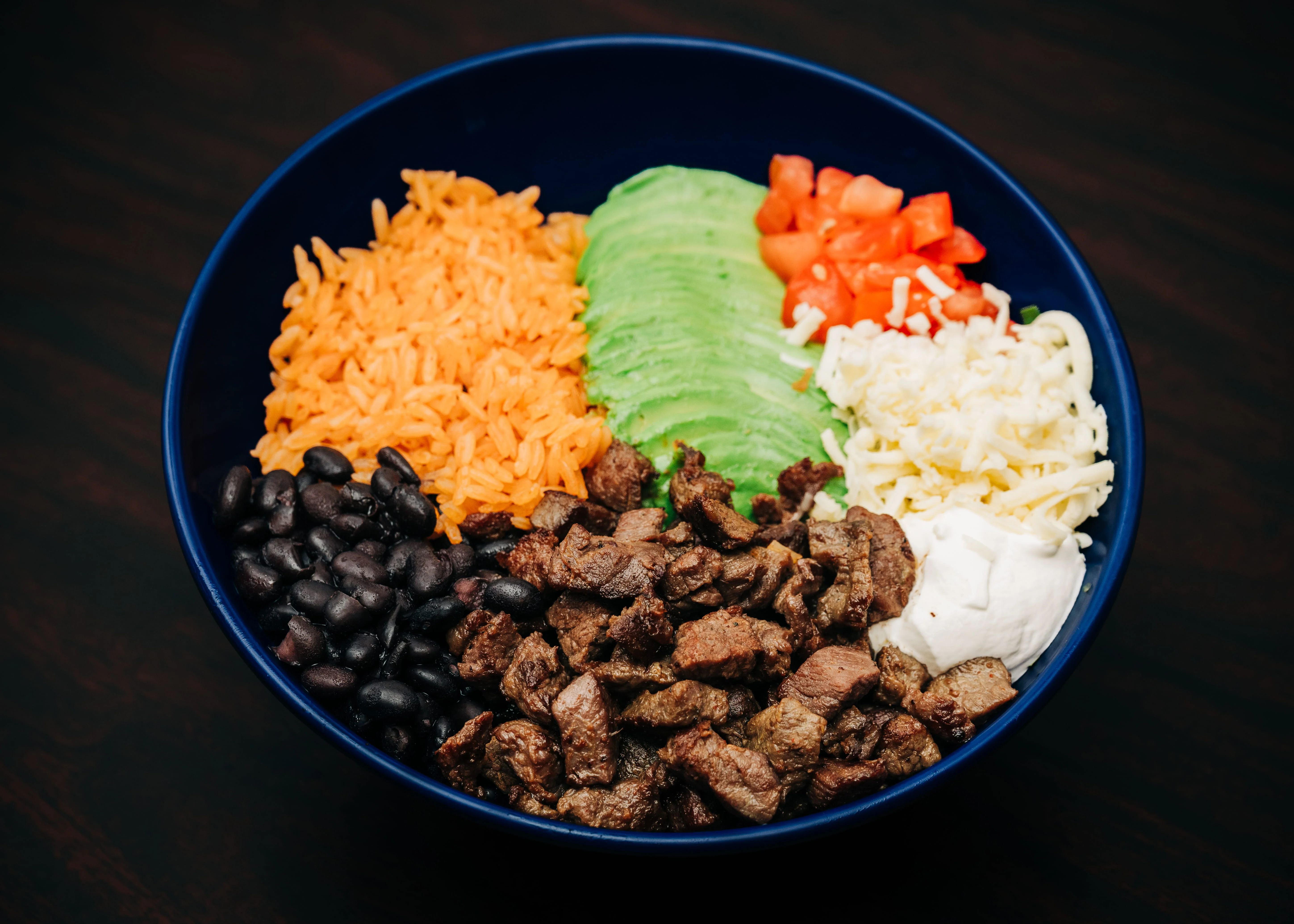 Colorful Mexican burrito bowl with steak and fresh toppings