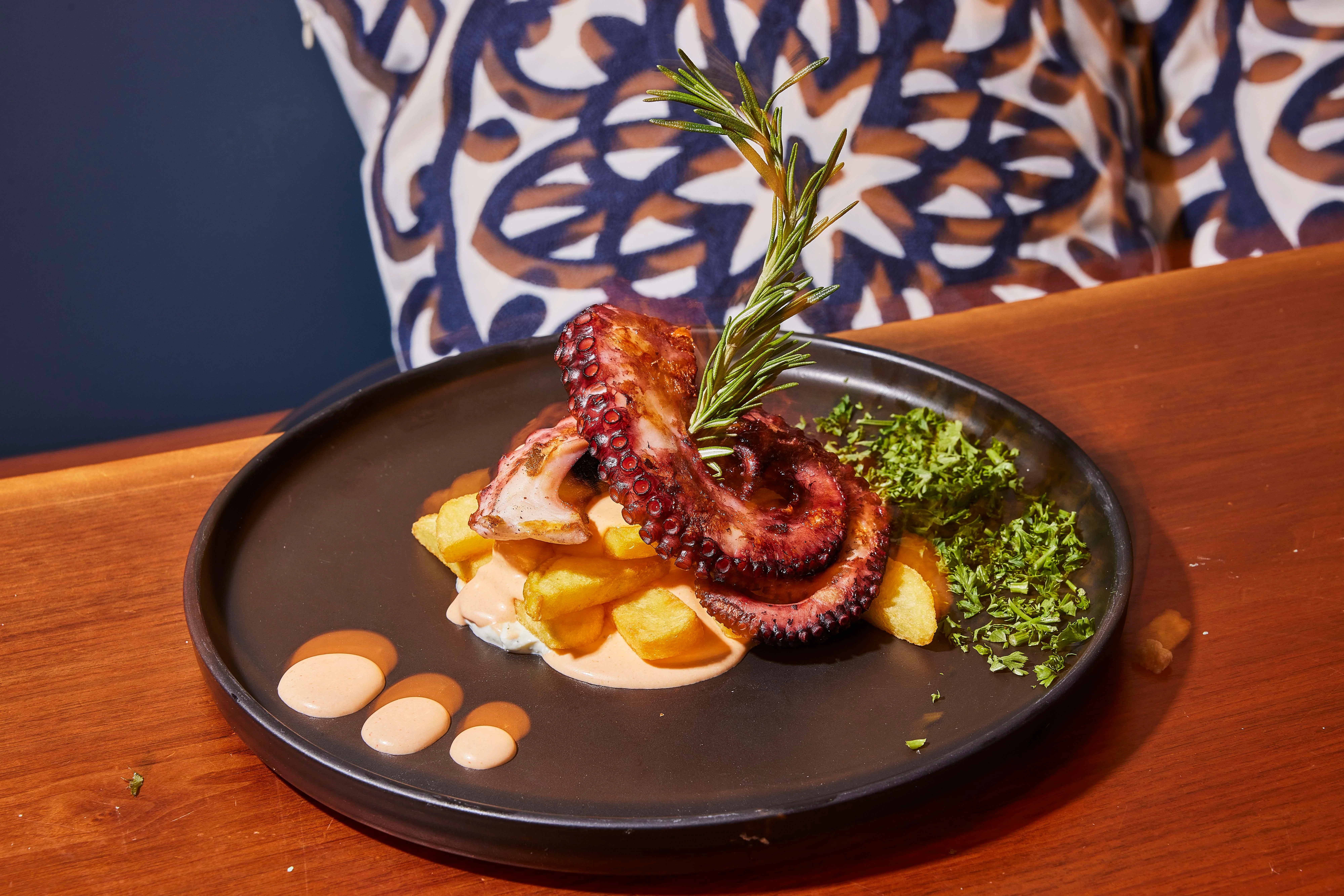 Gluten-free grilledcharred octopus served over fries or roasted potatoes at Sufrat Grill.