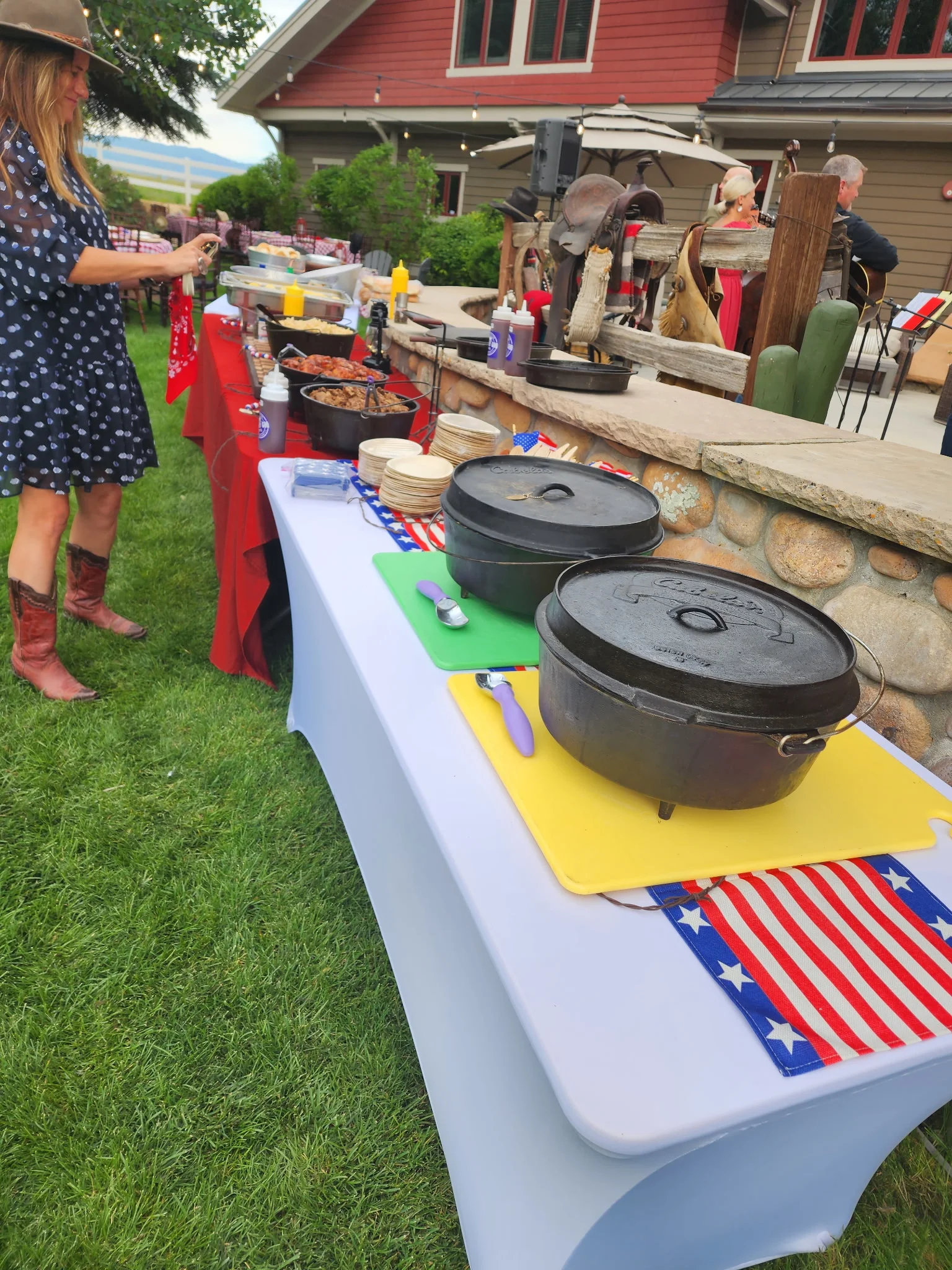 Outdoor barbecue setup with cast iron pots and festive decor