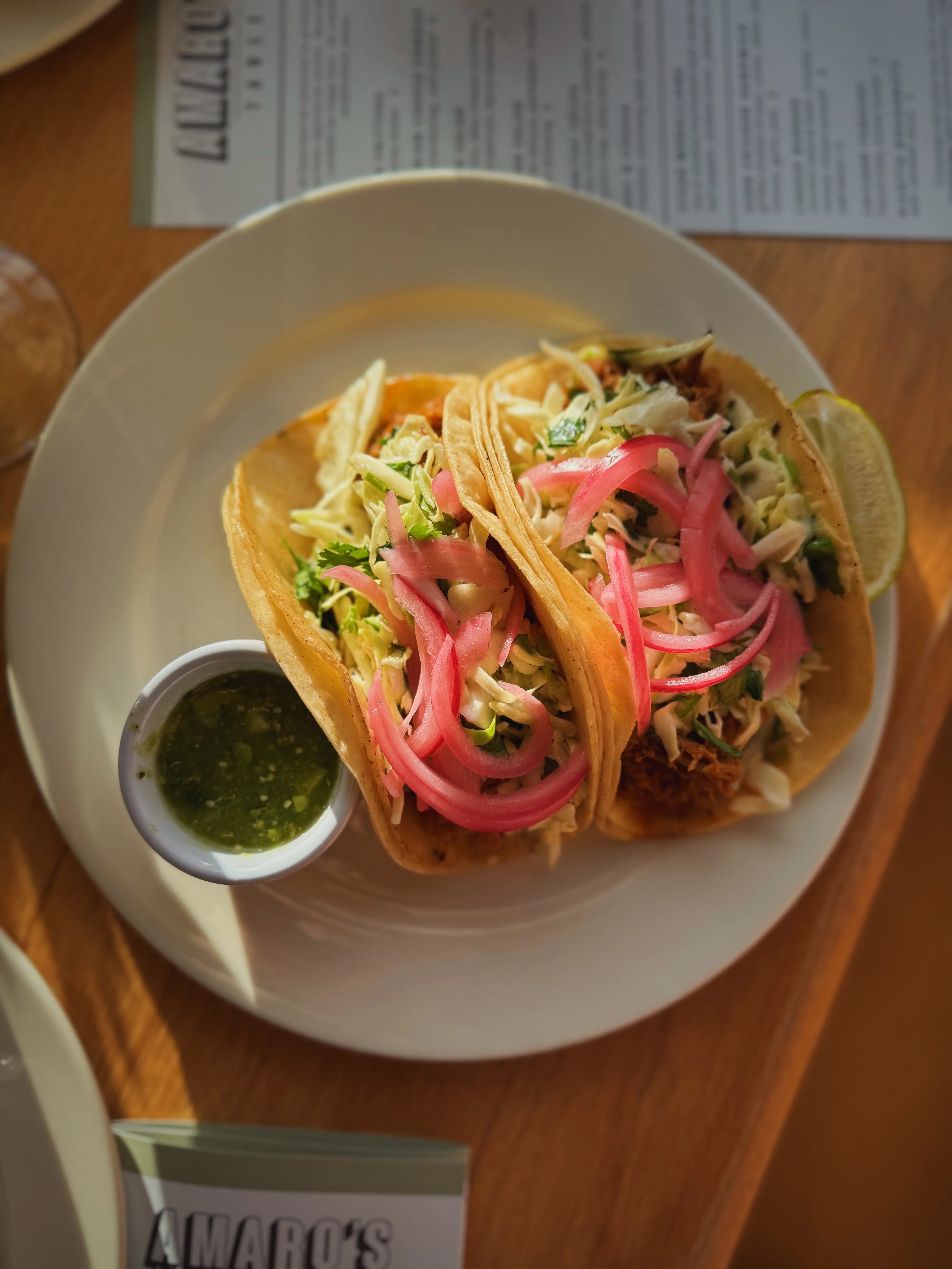 Two delicious tacos with pickled onions and salsa verde