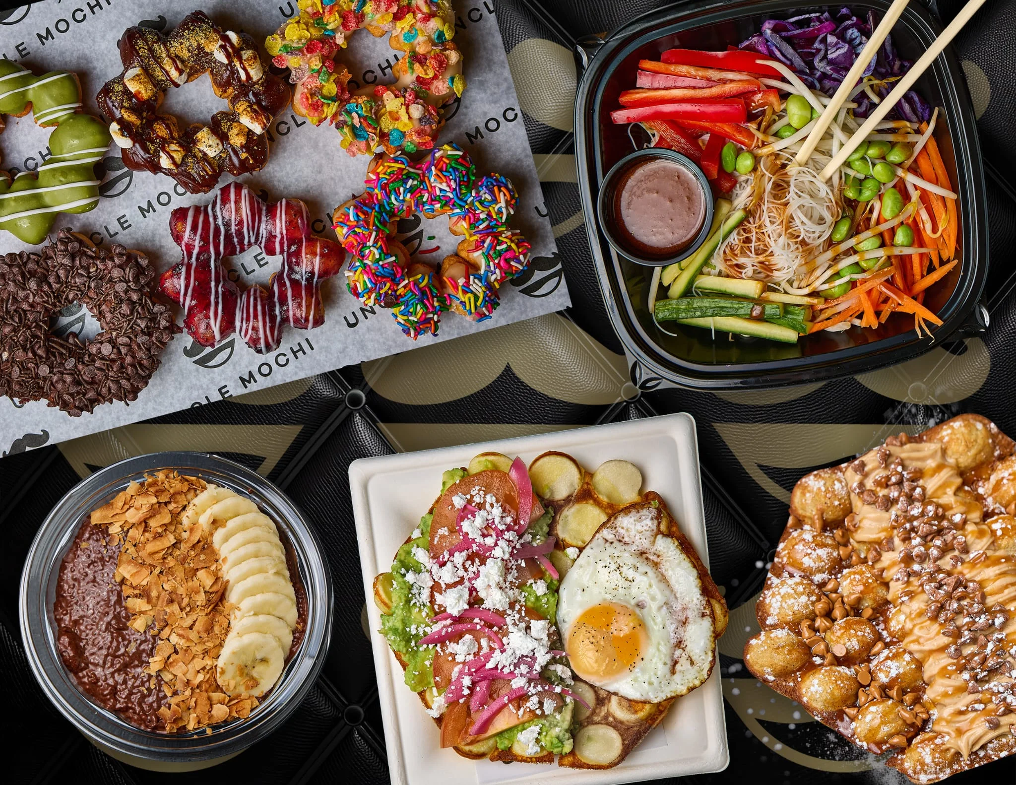 A colorful assortment of food including donuts, a salad bowl, and various plated dishes, showcasing diverse culinary options.