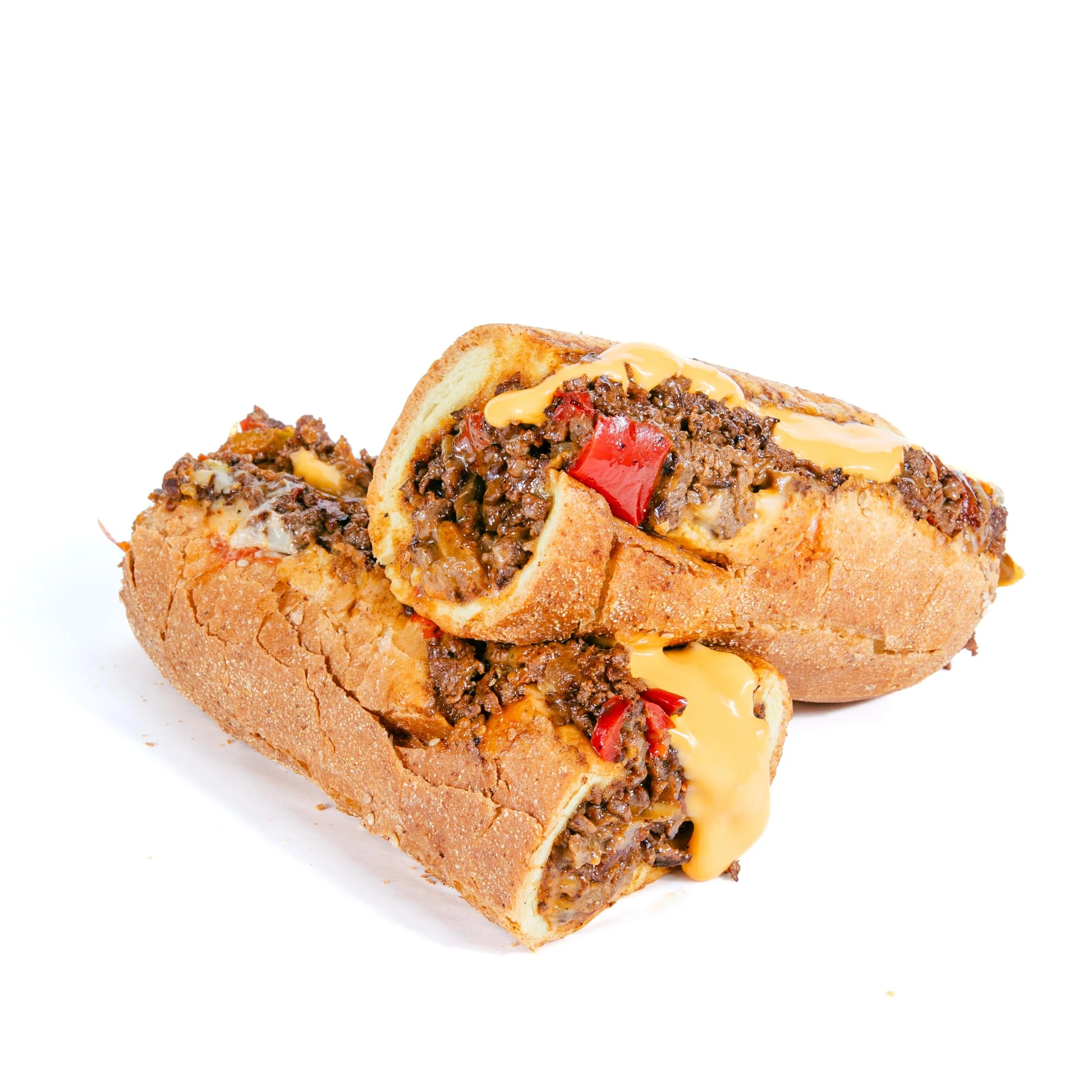 A hearty sandwich loaded with ground beef, peppers, and melted cheese in a rustic bread roll.