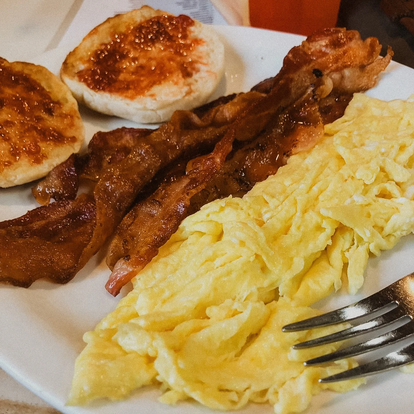 Classic American breakfast with eggs, bacon, and English muffins