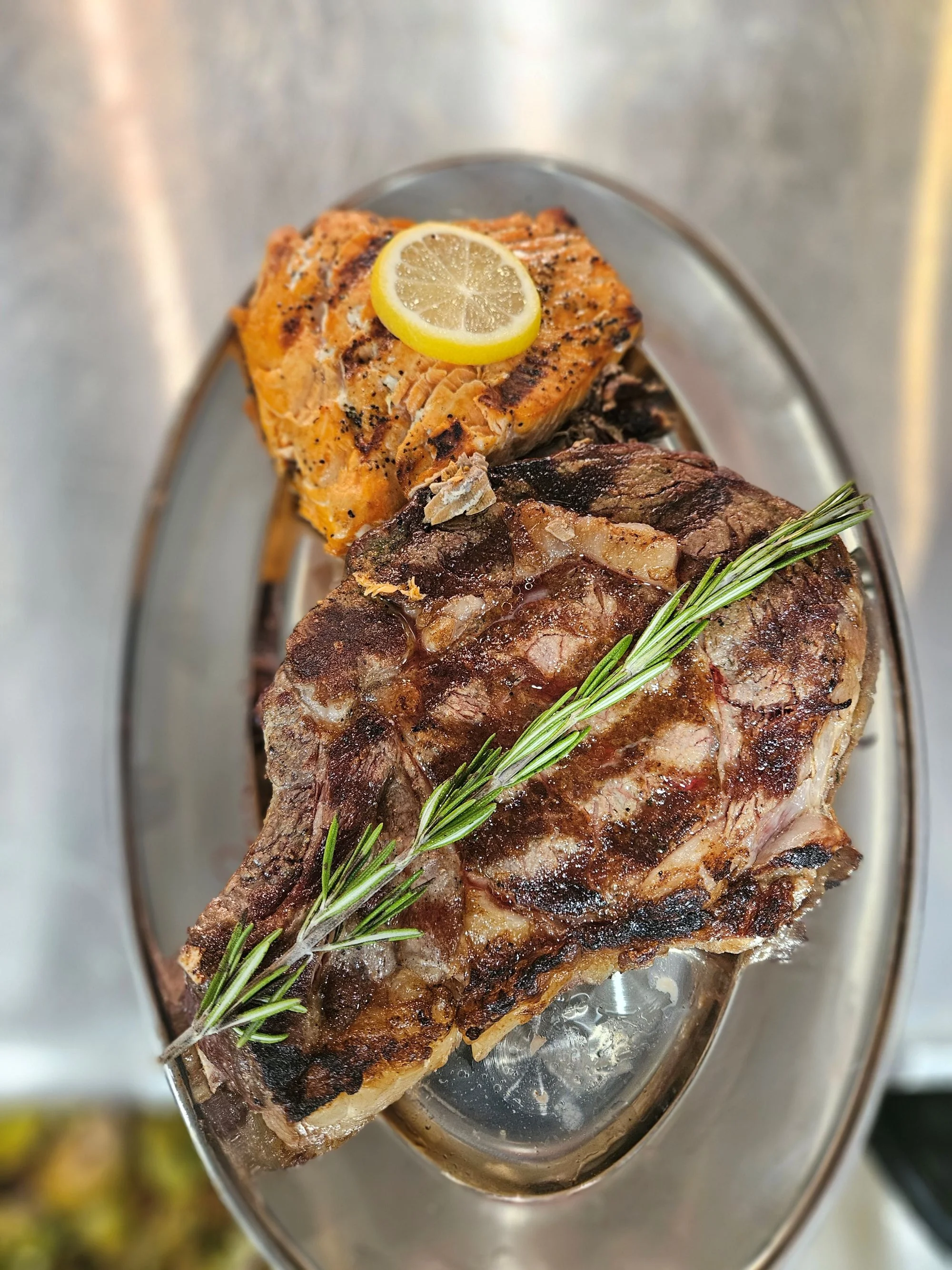 Grilled steak and salmon platter with lemon garnish