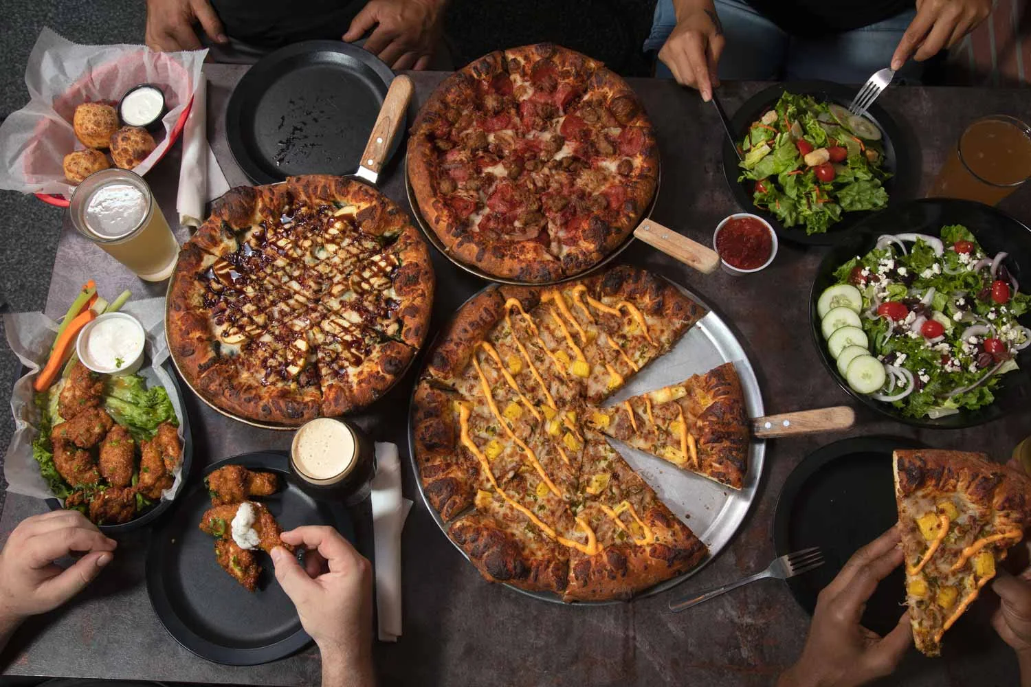 Delicious assortment of pizzas and salads on a restaurant table