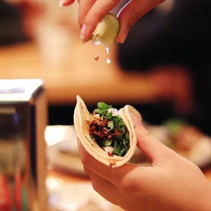 Crispy tortilla chips with guacamole in a taco bowl