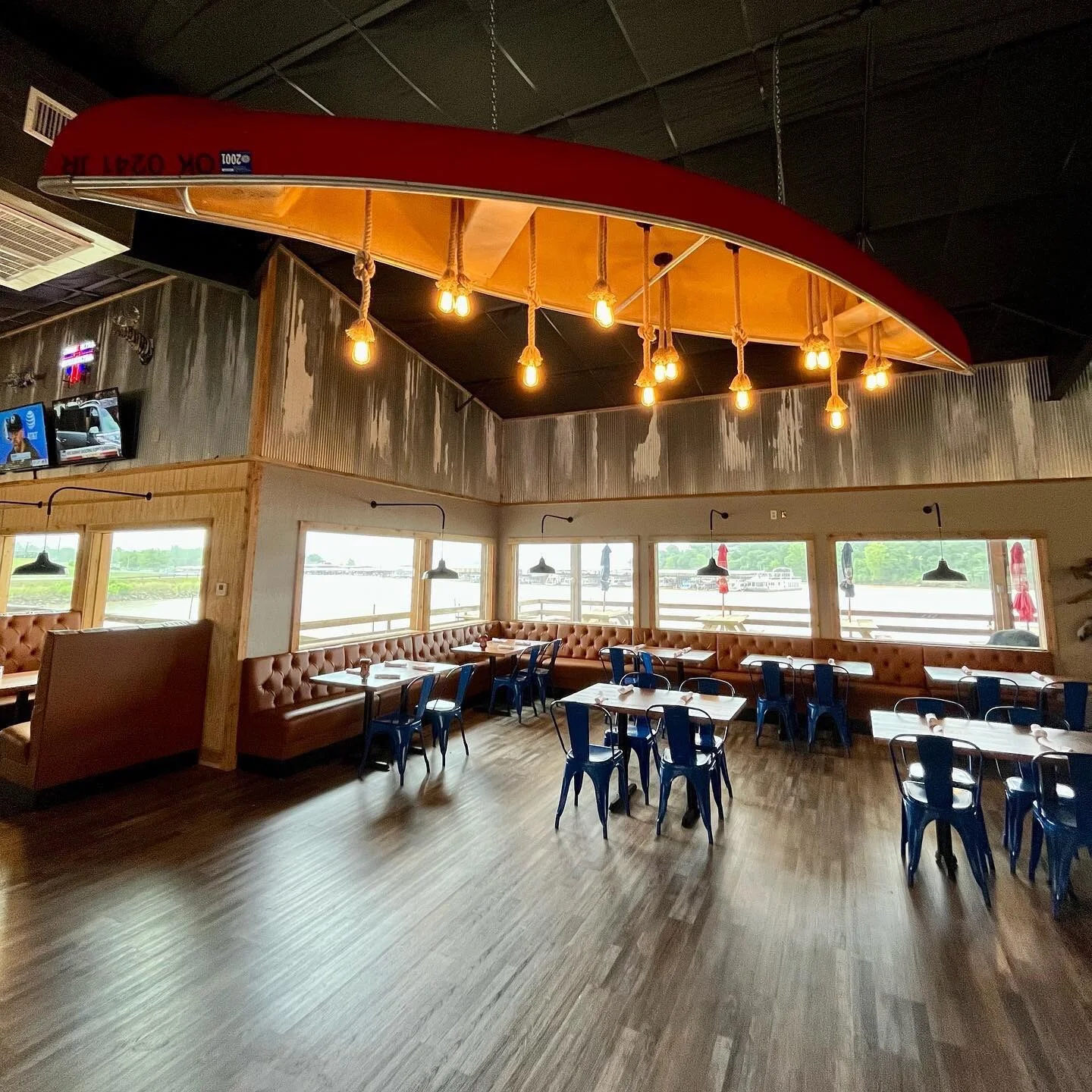 Stylish restaurant interior with cozy seating and unique canoe light fixture
