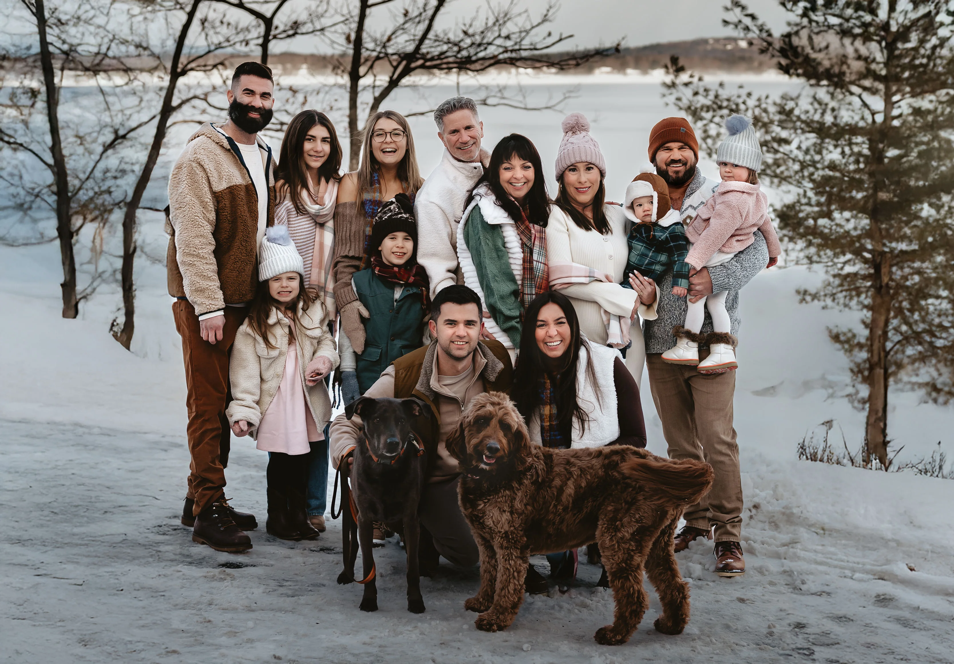Family portrait in winter attire with dogs in a snowy landscape