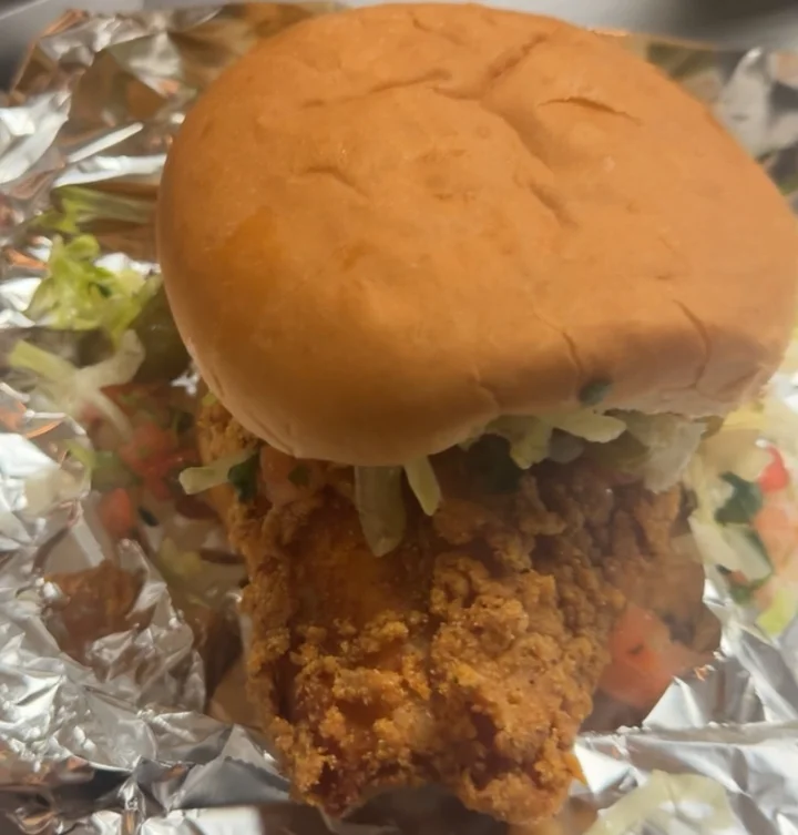 A crispy fried chicken sandwich filled with lettuce and topped with a soft bun.