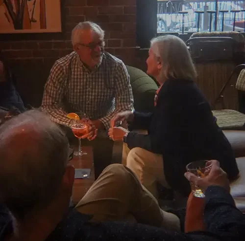 Cozy gathering with cocktails in a warm, rustic bar setting