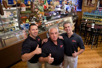 Friendly restaurant staff posing in a vibrant deli interior