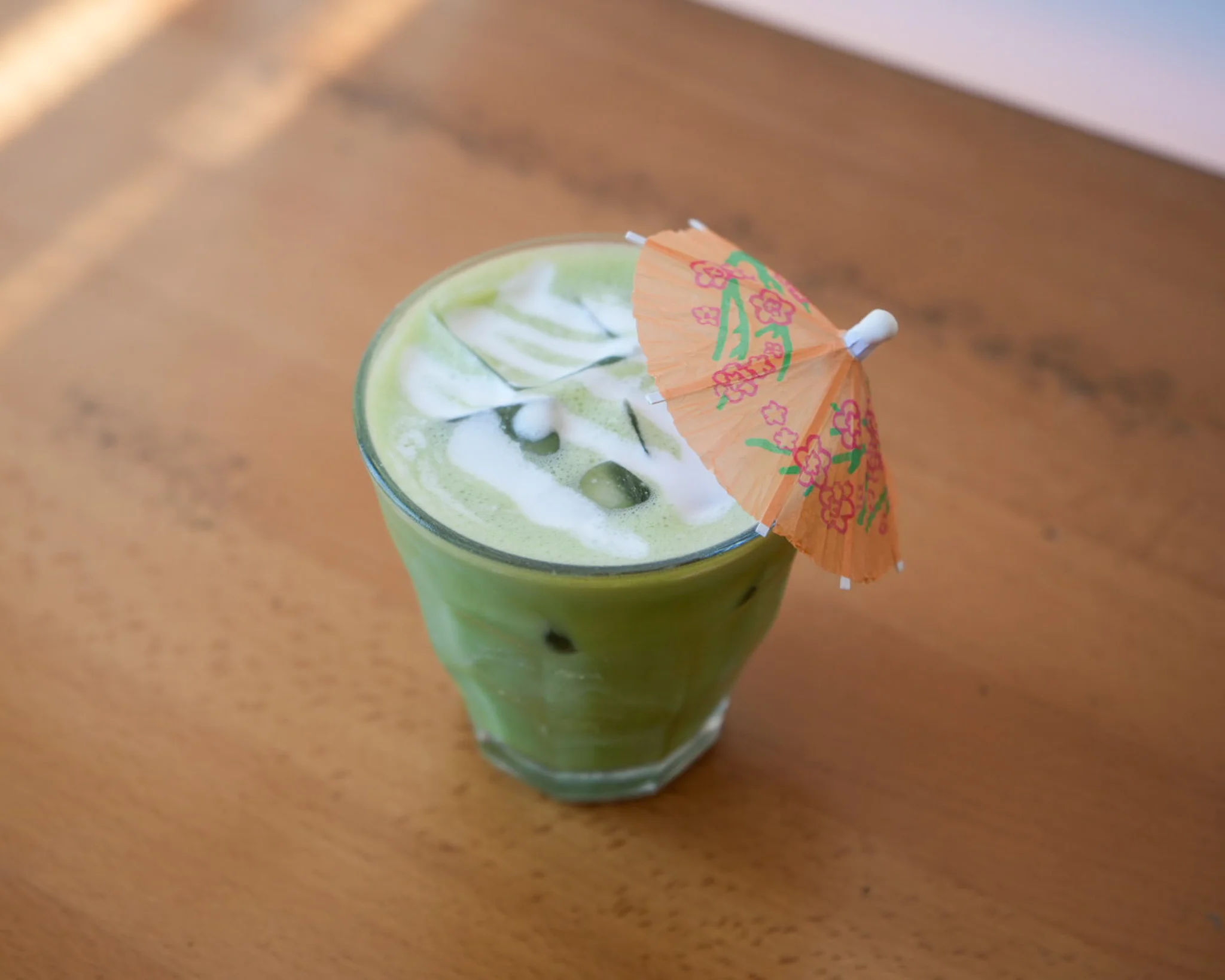 Iced matcha latte with decorative umbrella
