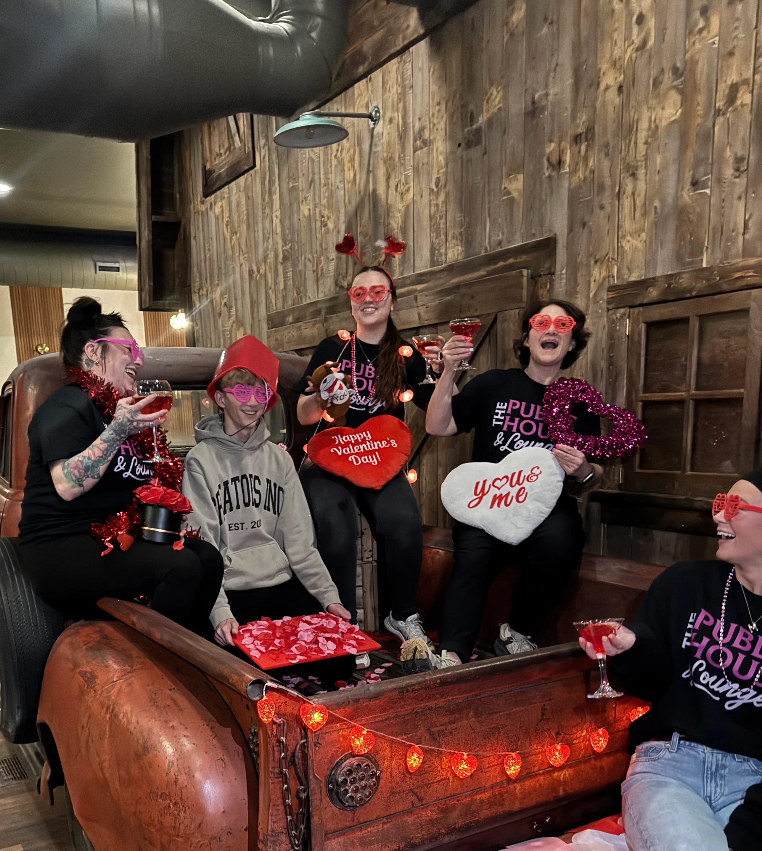 Group of friends celebrating Valentine's Day with drinks and decorations.