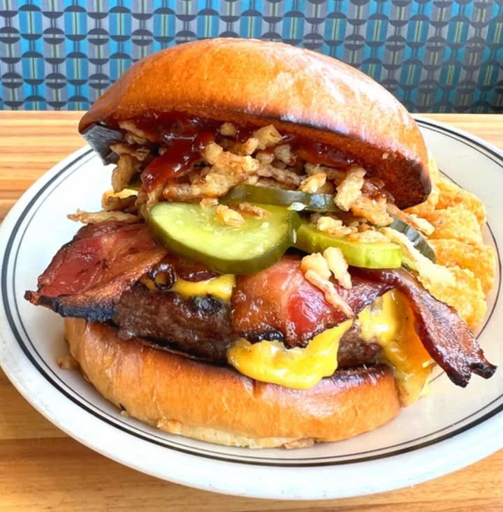 Juicy American cheeseburger with bacon and crispy toppings