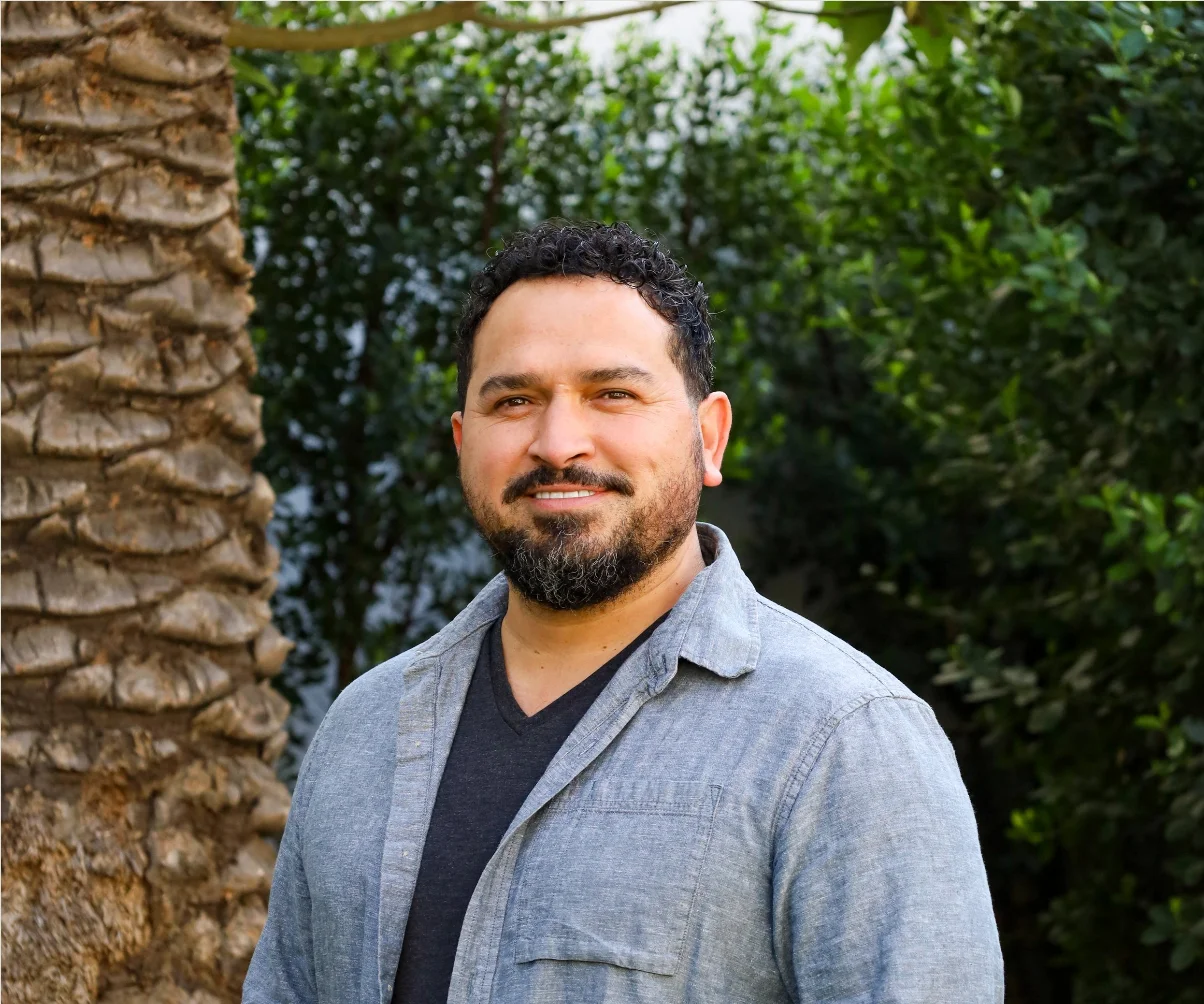 Portrait of a man outdoors with greenery in the background