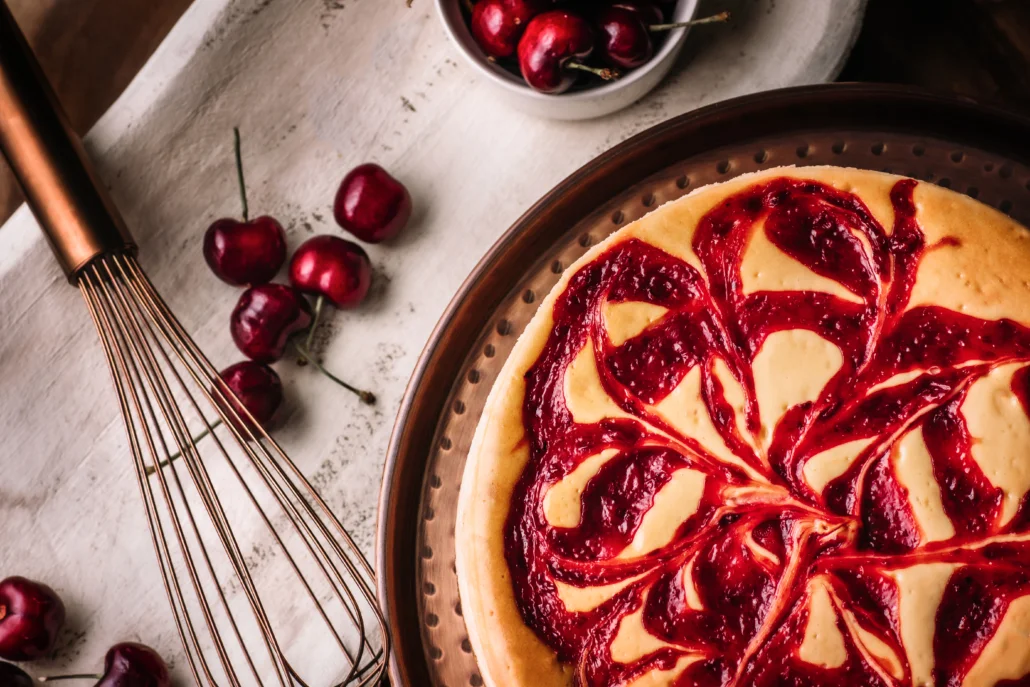 Delicious cheesecake topped with cherry sauce and fresh cherries.