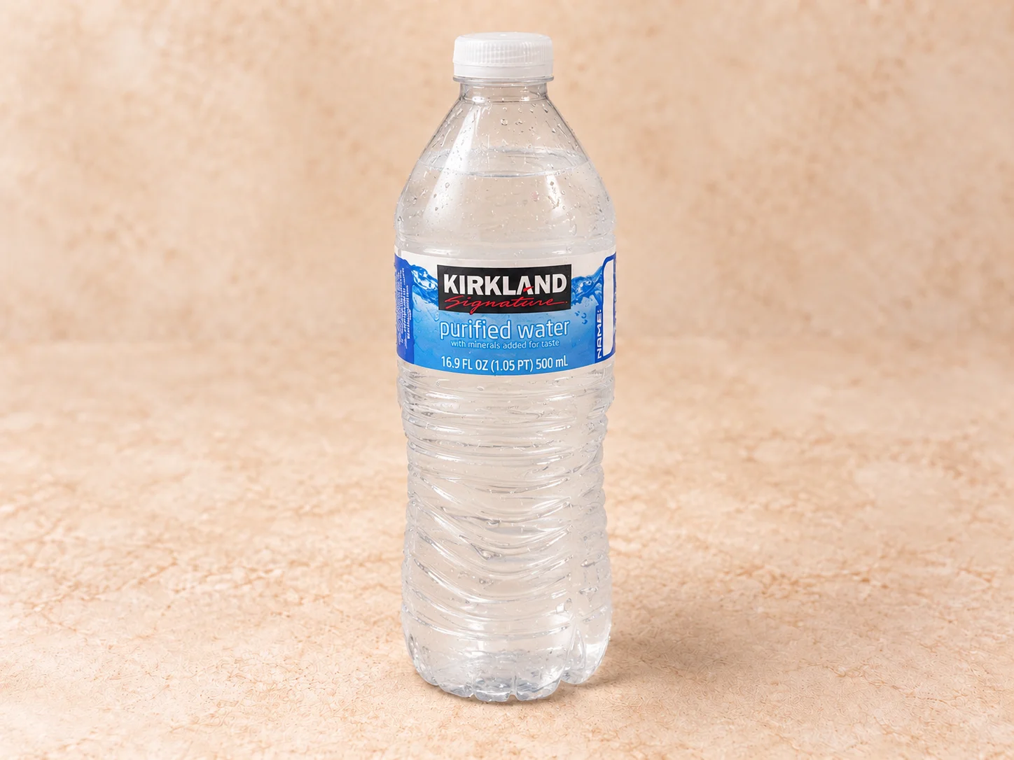 A bottle of purified water with a blue label, showcasing its freshness and clarity.