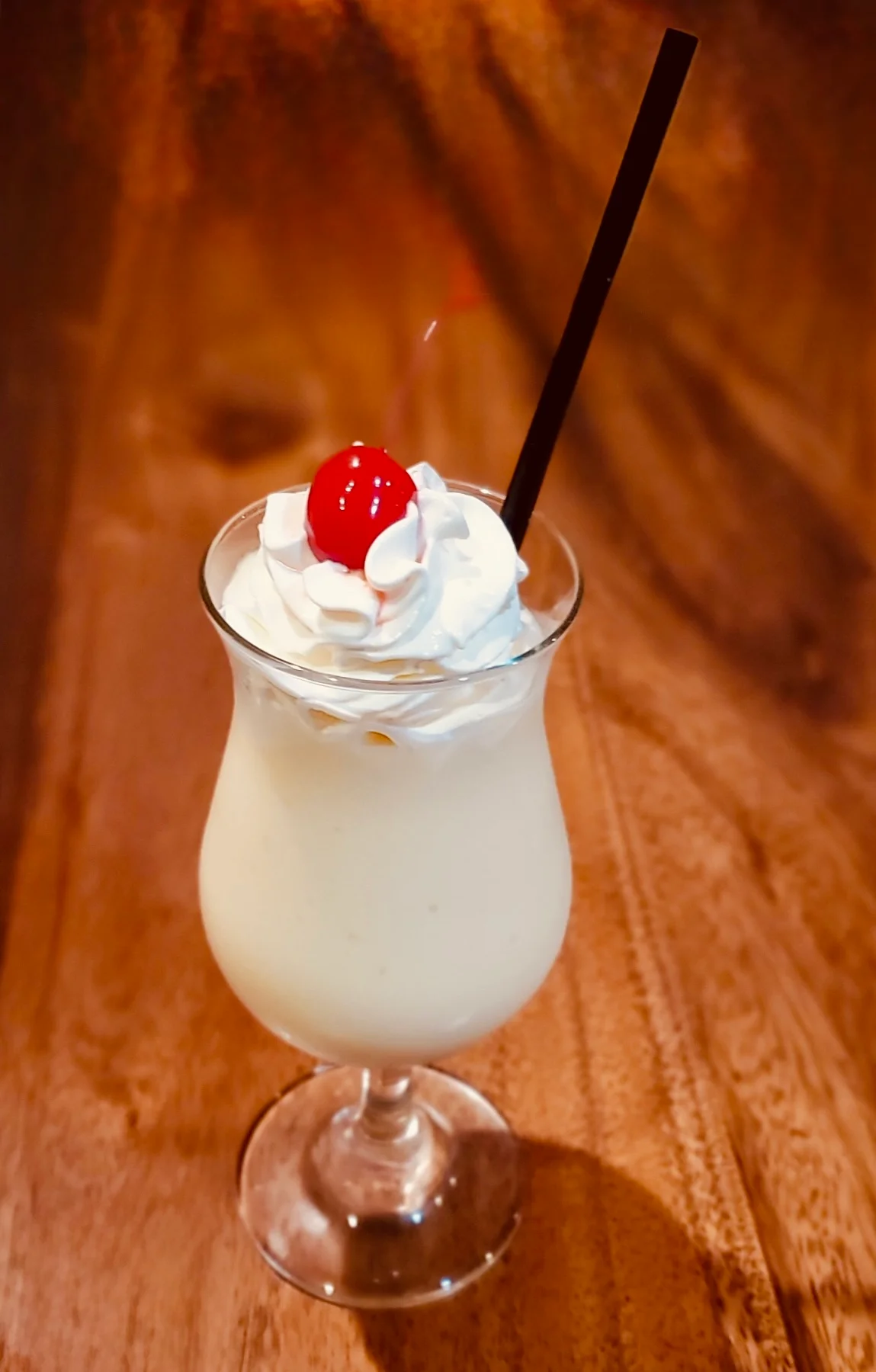Classic piña colada topped with whipped cream and cherry
