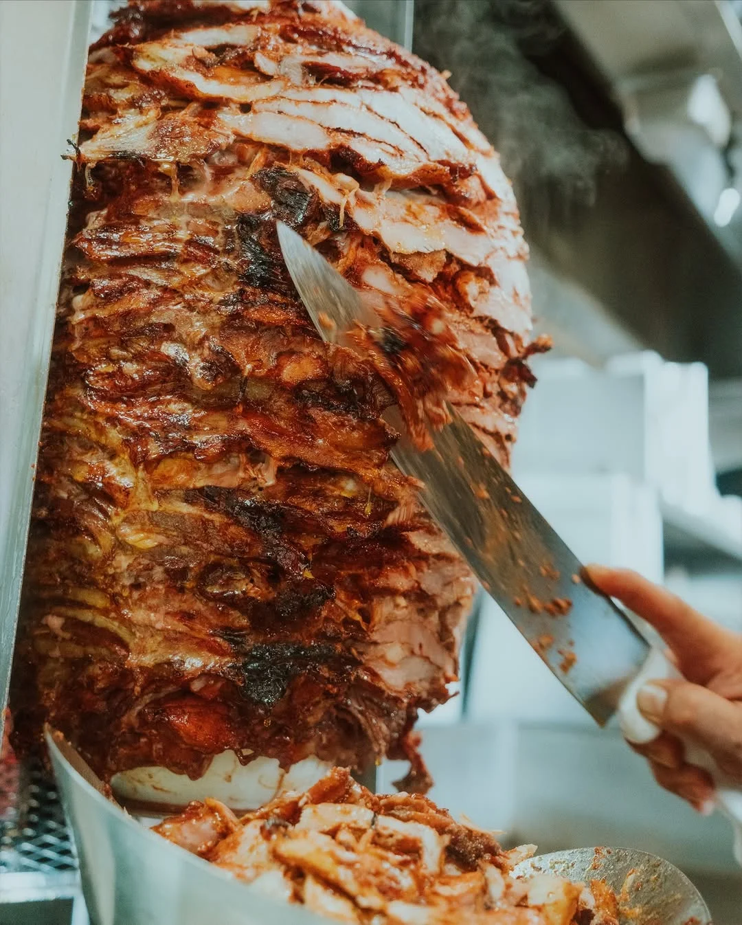 Vertical shawarma meat on a rotisserie in a restaurant kitchen