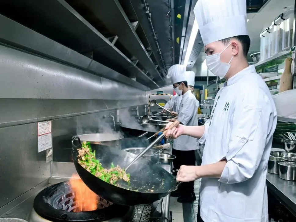 Chefs preparing stir-fry in a professional kitchen