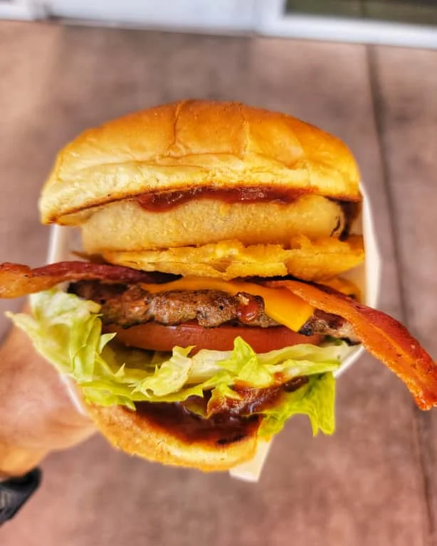 Juicy American cheeseburger with bacon and crispy onion rings
