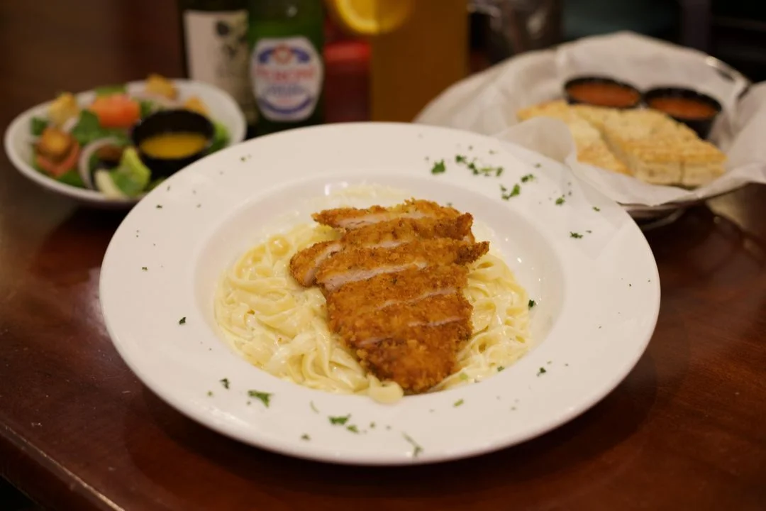 Crispy chicken fettuccine Alfredo with salad and breadsticks