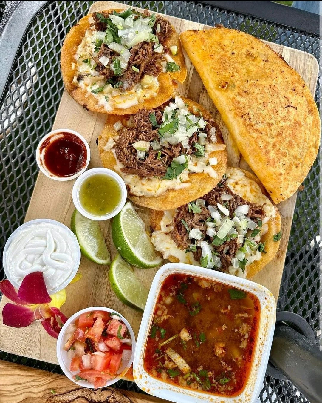 Delicious Mexican tacos with beef and toppings on a wooden platter