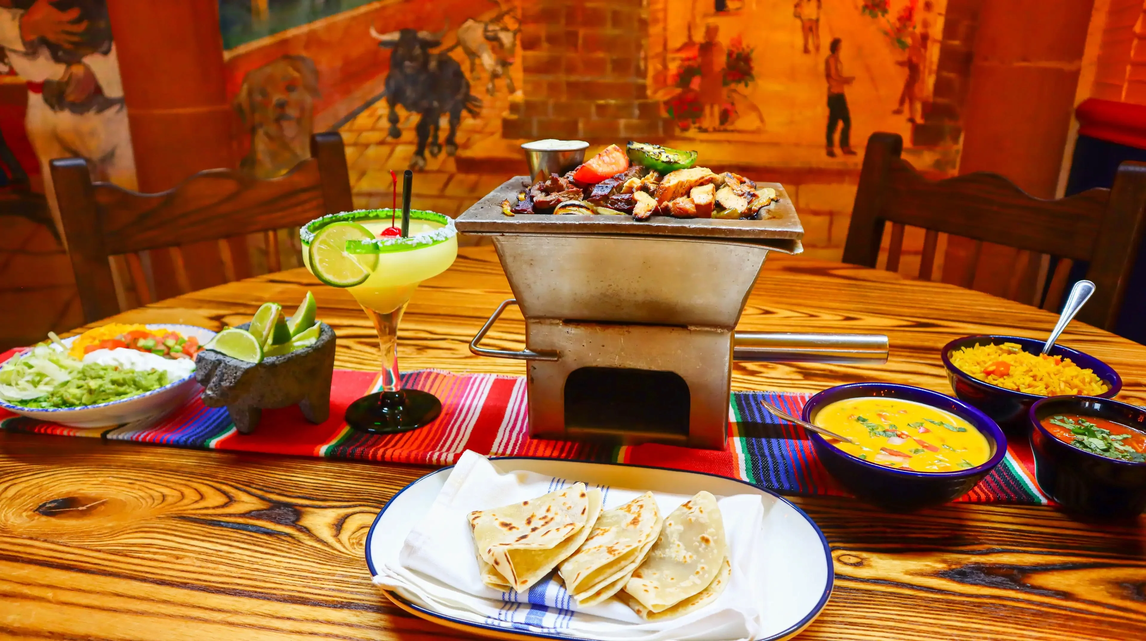 Sizzling fajitas served with tortillas and margarita in a vibrant restaurant