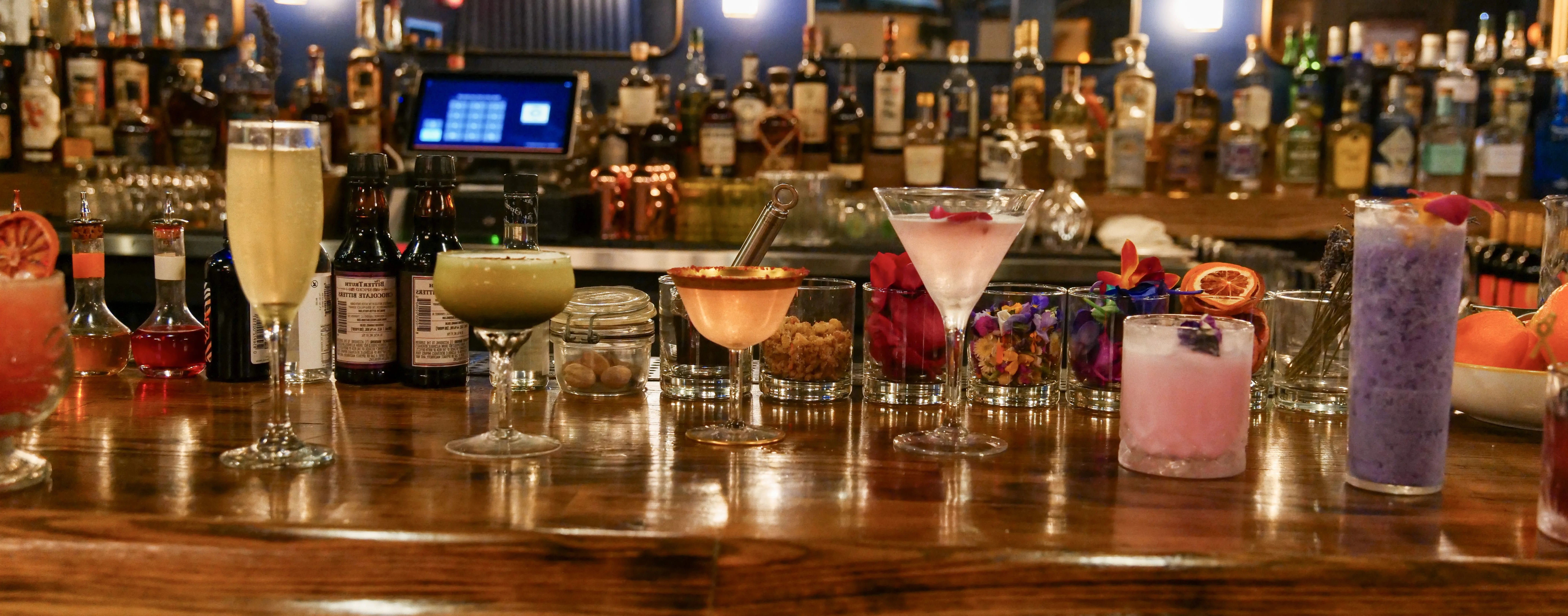 Colorful cocktails displayed on a wooden bar counter