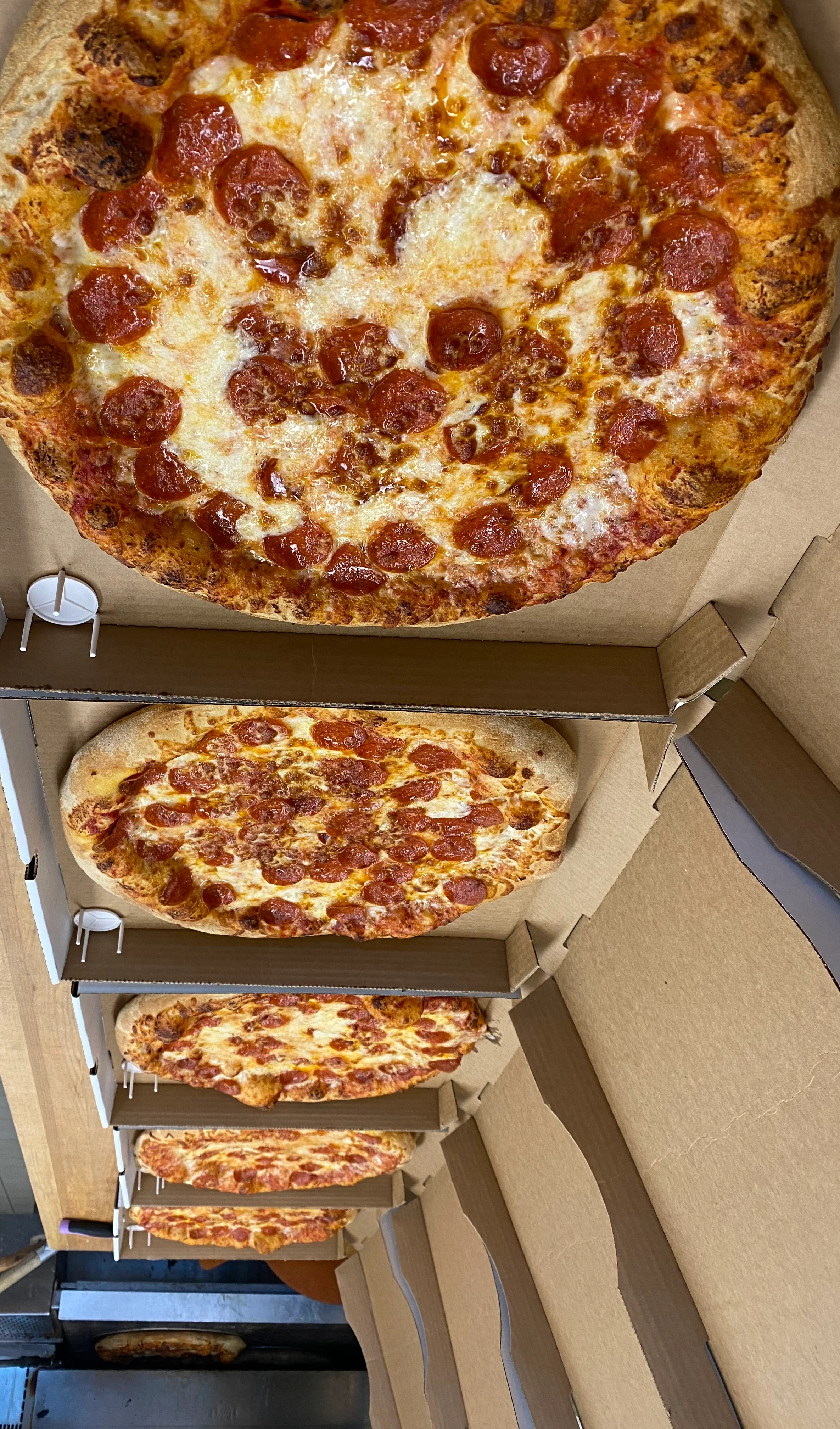 Freshly baked pepperoni pizza in cardboard boxes