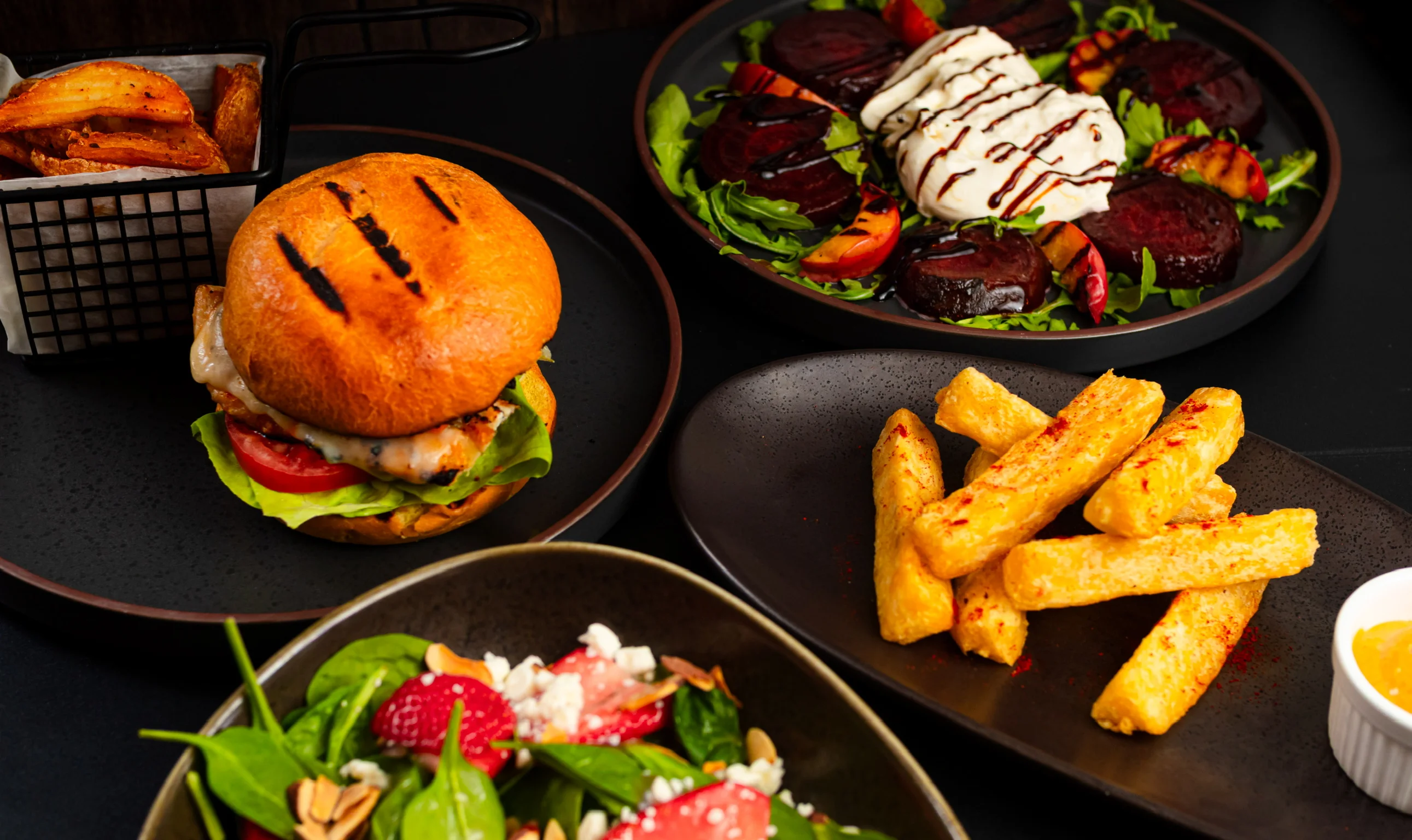 Gourmet burger with sweet potato fries and fresh salad