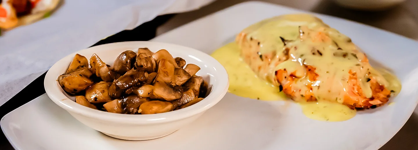 Grilled salmon with hollandaise sauce and sautéed mushrooms