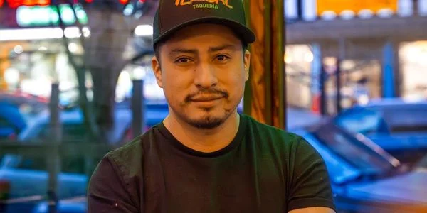 Chef posing in a vibrant taqueria setting