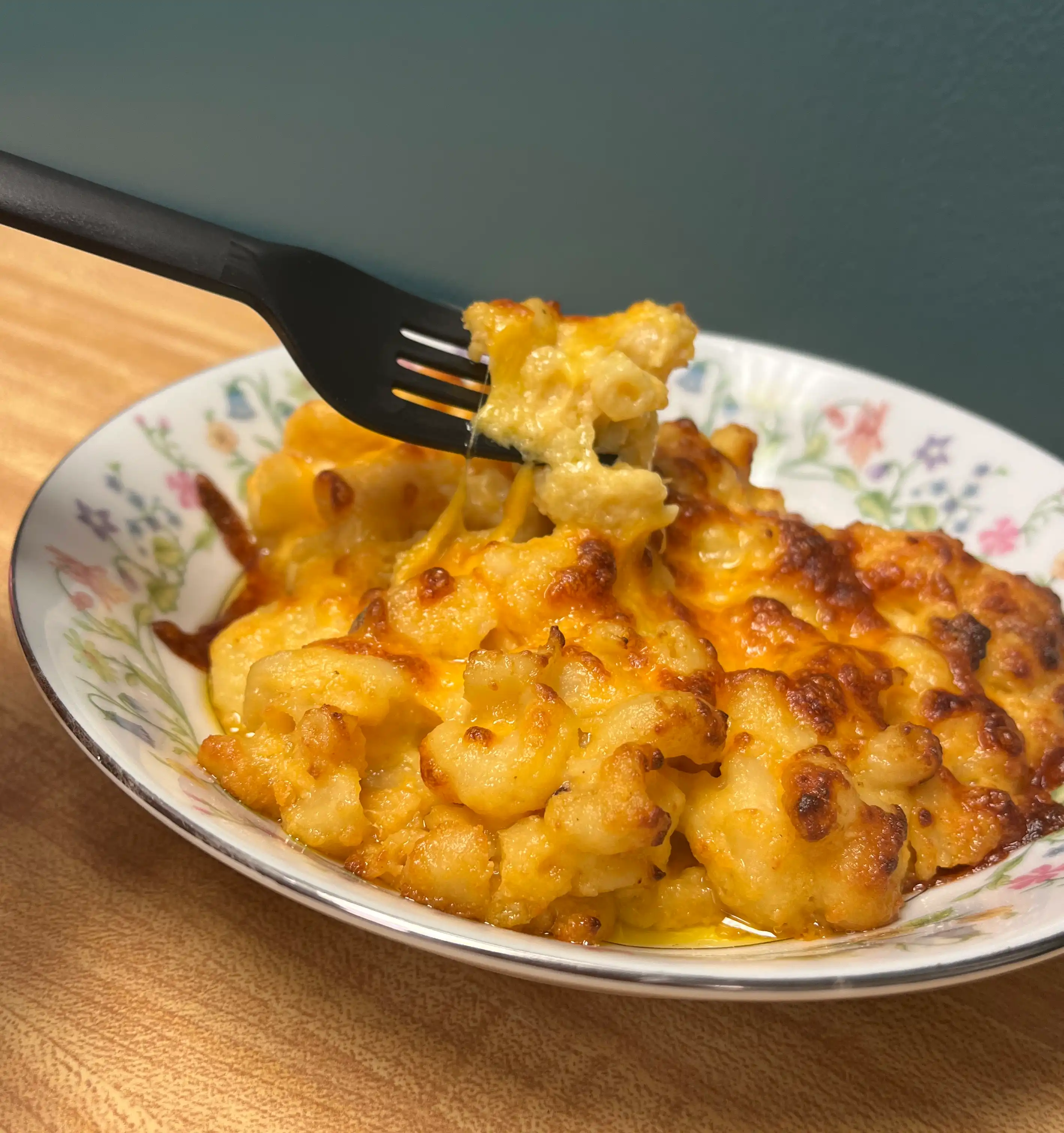 A bowl of made-from-scratch macaroni and cheese with a fork digging into it.