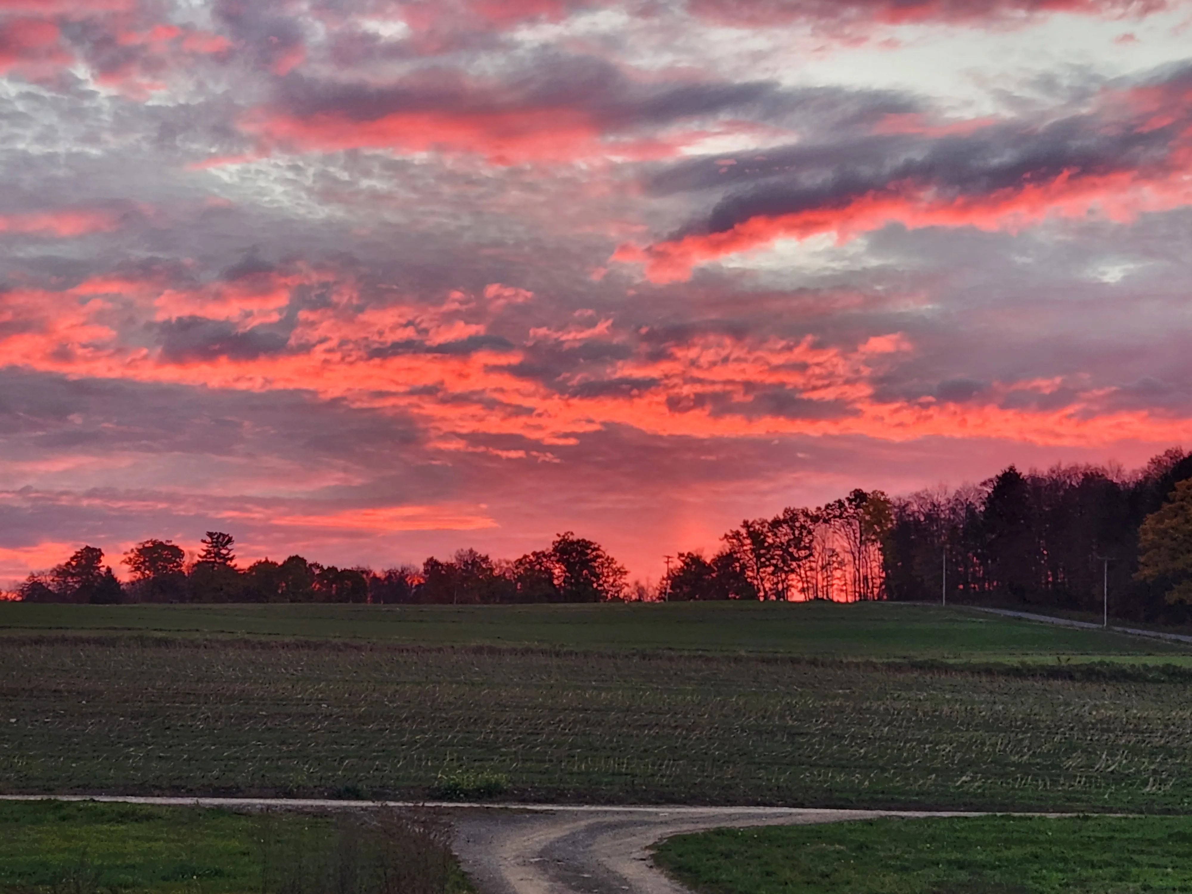 Vibrant sunset over a rural landscape with colorful clouds