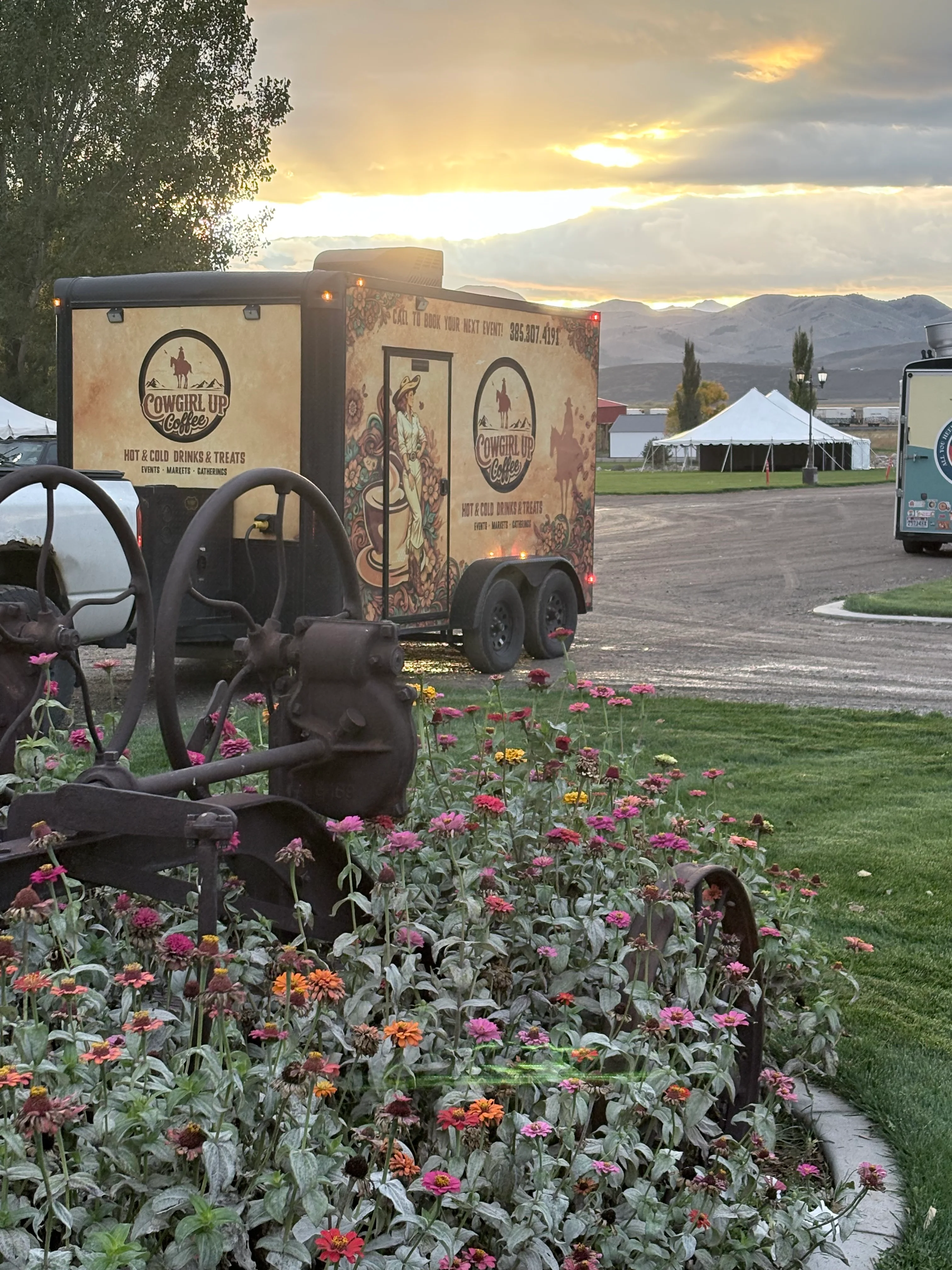 Coffee trailer beside a flower garden with mountain sunset backdrop