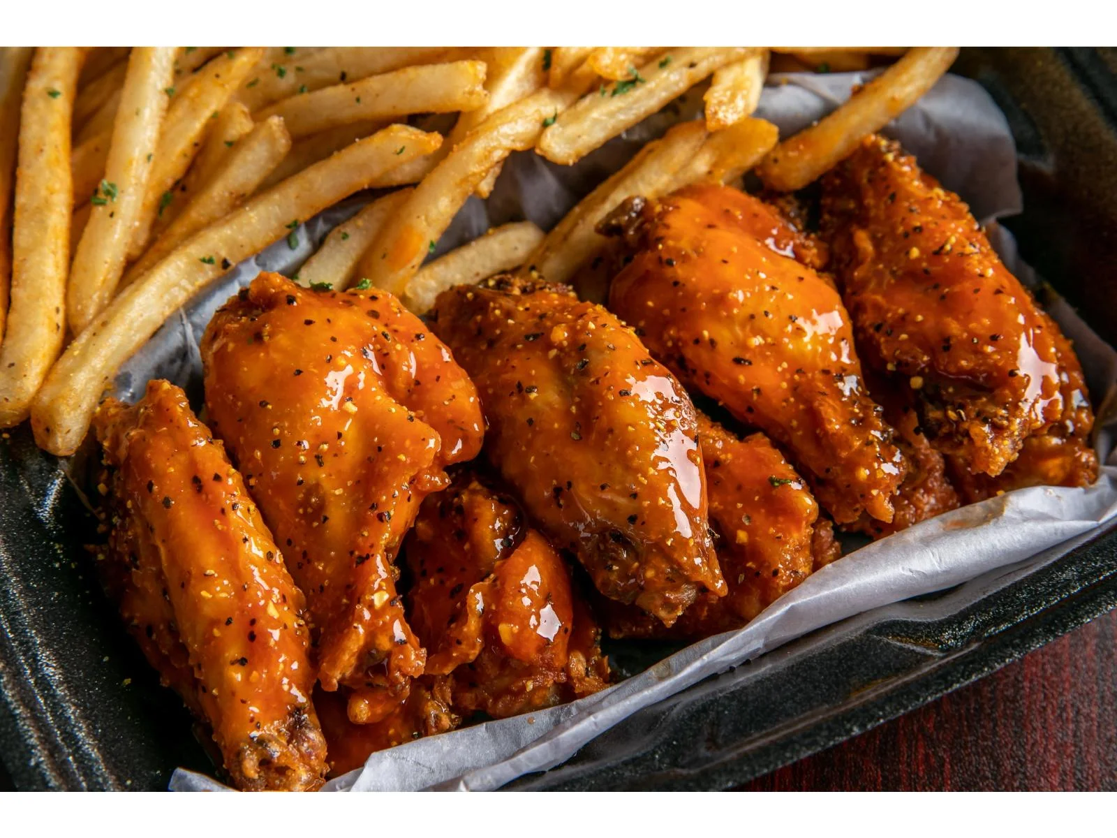 Crispy buffalo chicken wings with fries