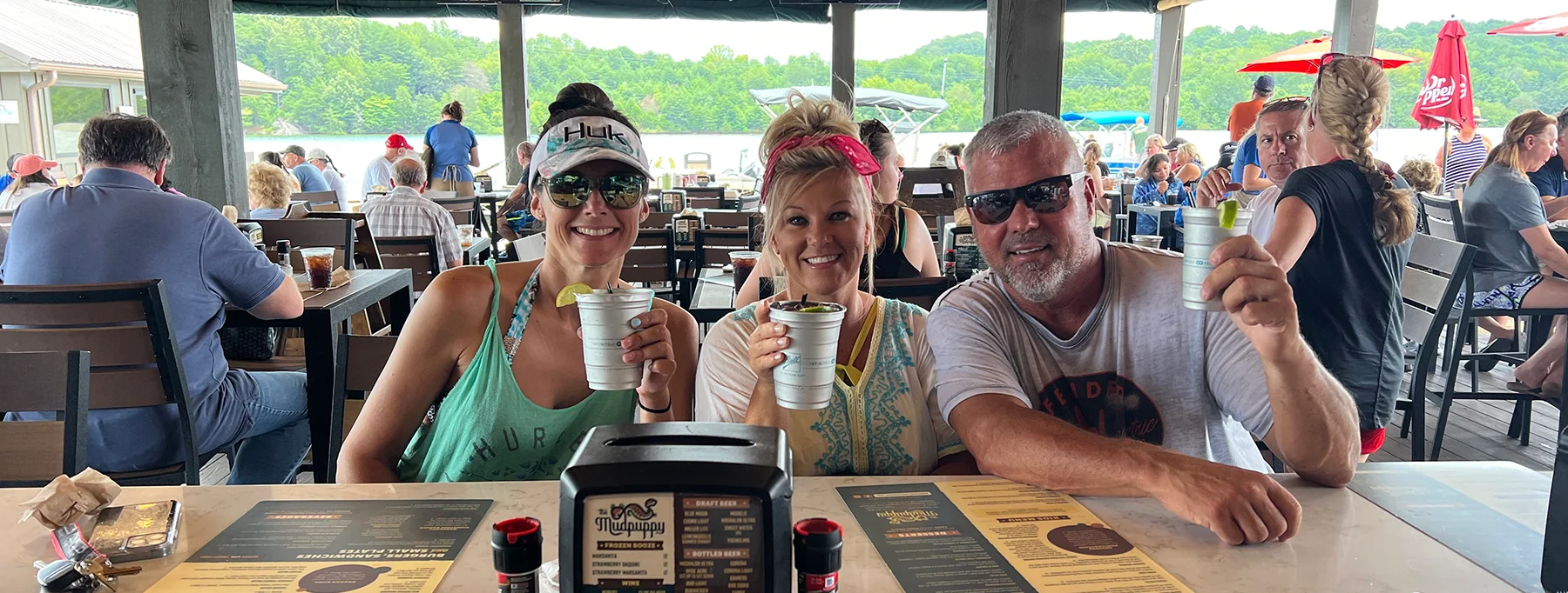 Friends enjoying drinks at a lively lakeside restaurant
