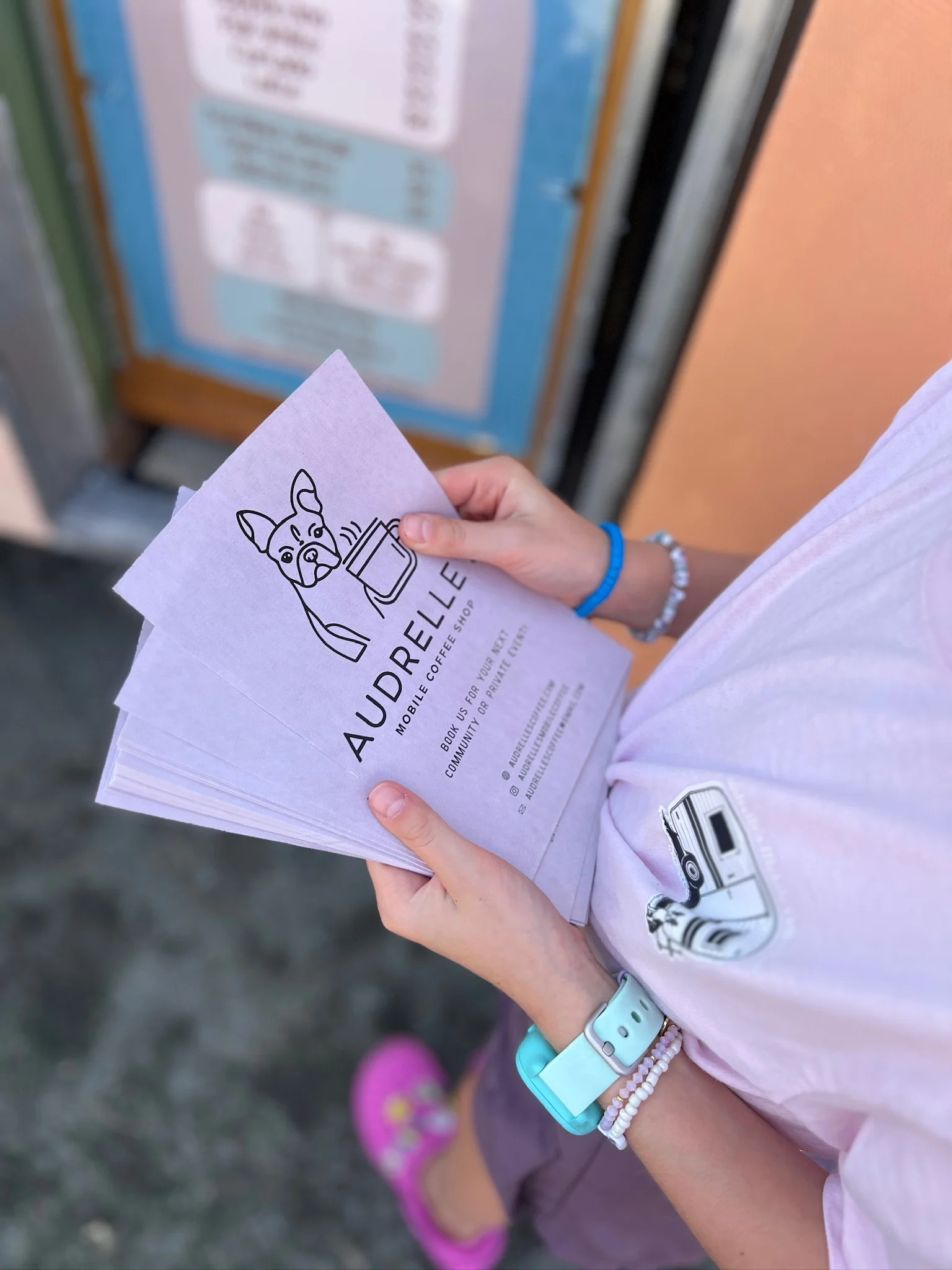 Hand holding mobile coffee shop menu with dog illustration