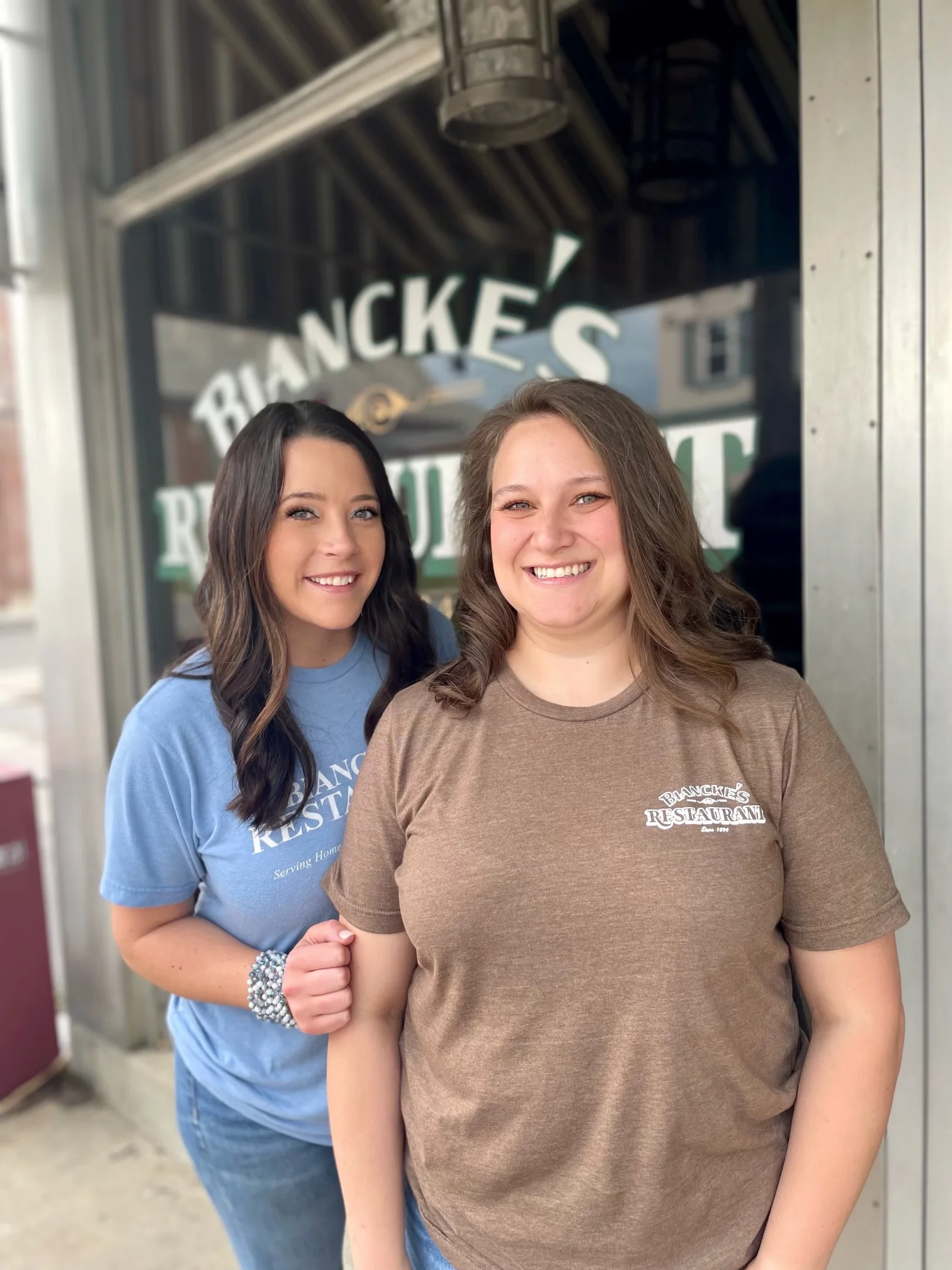 Two smiling staff members outside Biancke's Restaurant