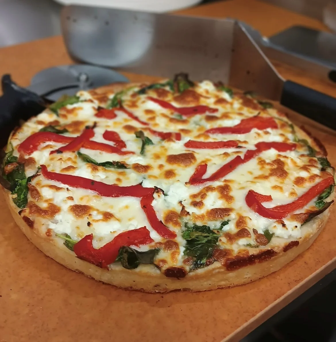 Vegetarian pizza with red peppers and fresh greens
