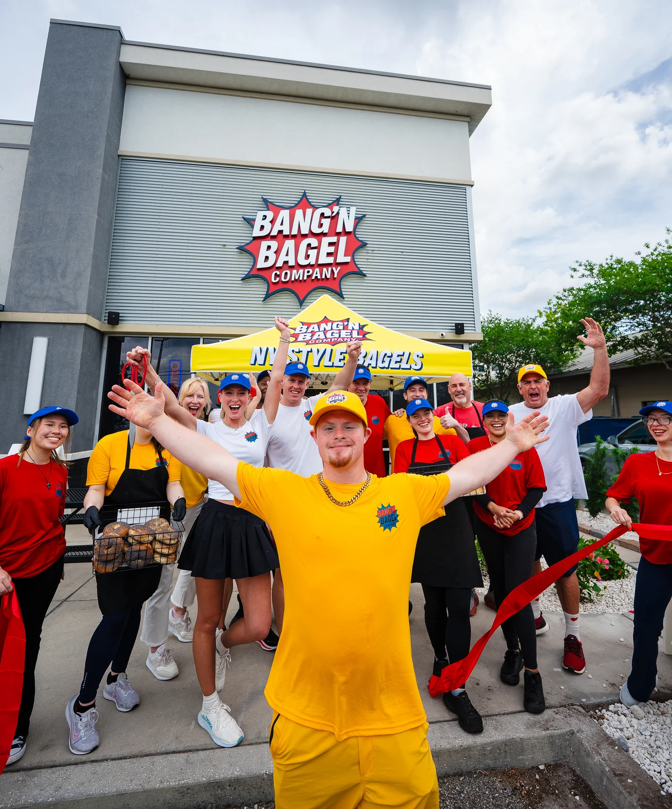 Celebration at Bang'n Bagel Company with staff and a ribbon-cutting event.