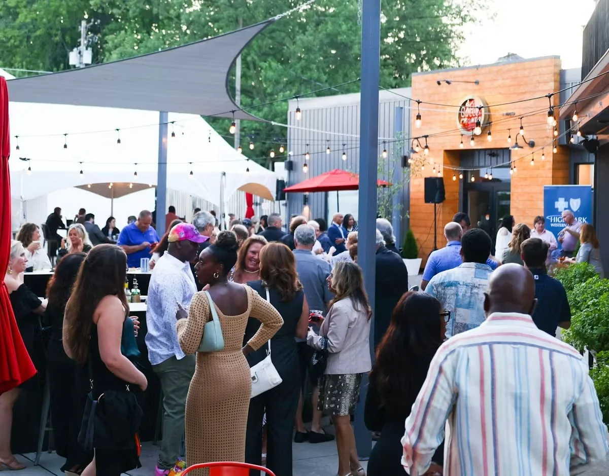 Outdoor event with guests mingling at a restaurant gathering.